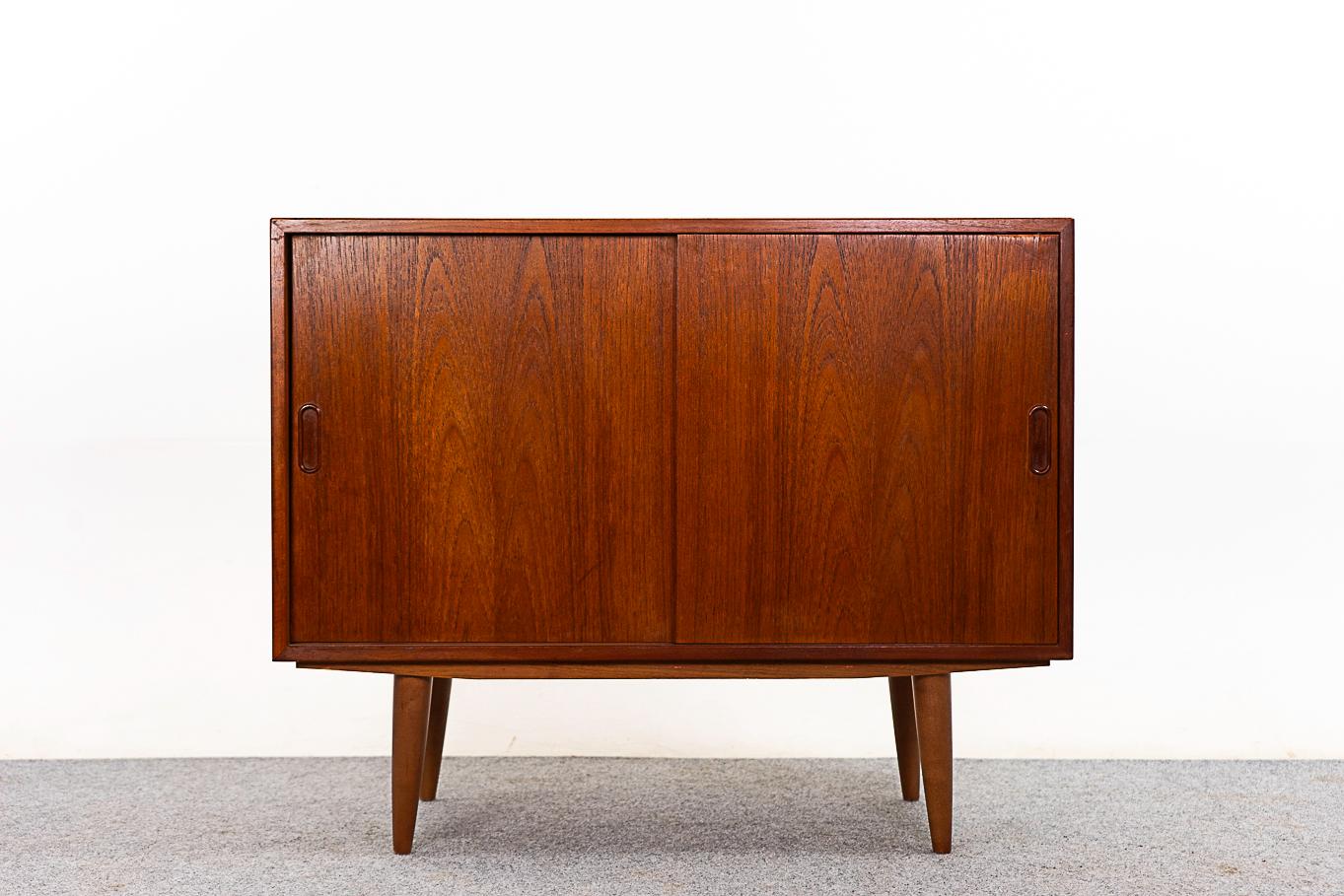 Schrank aus Teakholz aus der Mitte des Jahrhunderts, circa 1960er Jahre. Das klare, schlichte Liniendesign unterstreicht das außergewöhnliche, durchgehend buchstabierte Furnier. Verstellbares Regal, abnehmbare Beine. Türecke hat