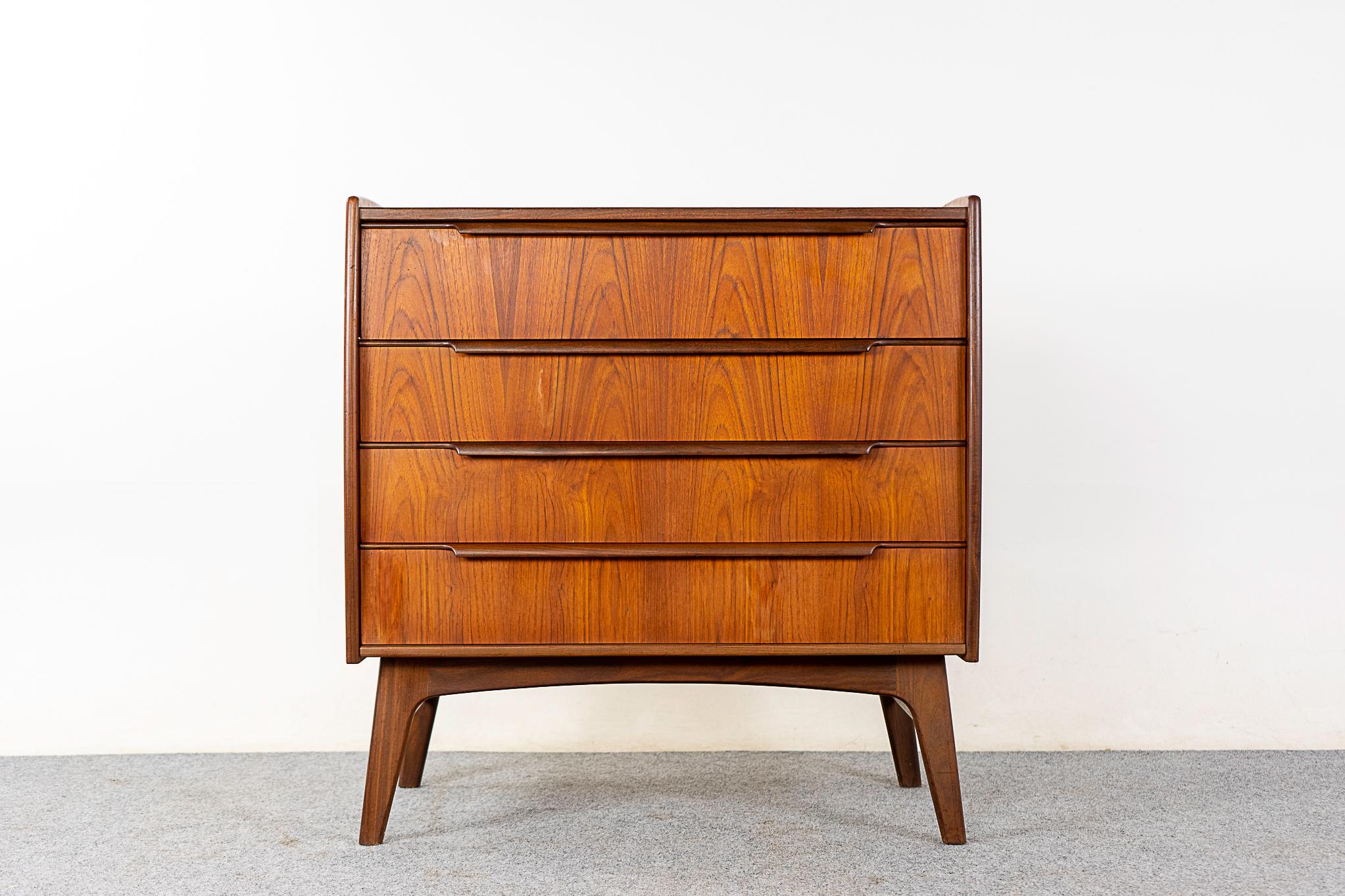 Teak Danish vanity/dresser, circa 1960's. Slide out table platform opens to an amoeboid shaped mirror, black glass surface and sleek storage. Solid wood trim, stunning book-matched veneer drawer faces with dovetail construction. Solid wood base with