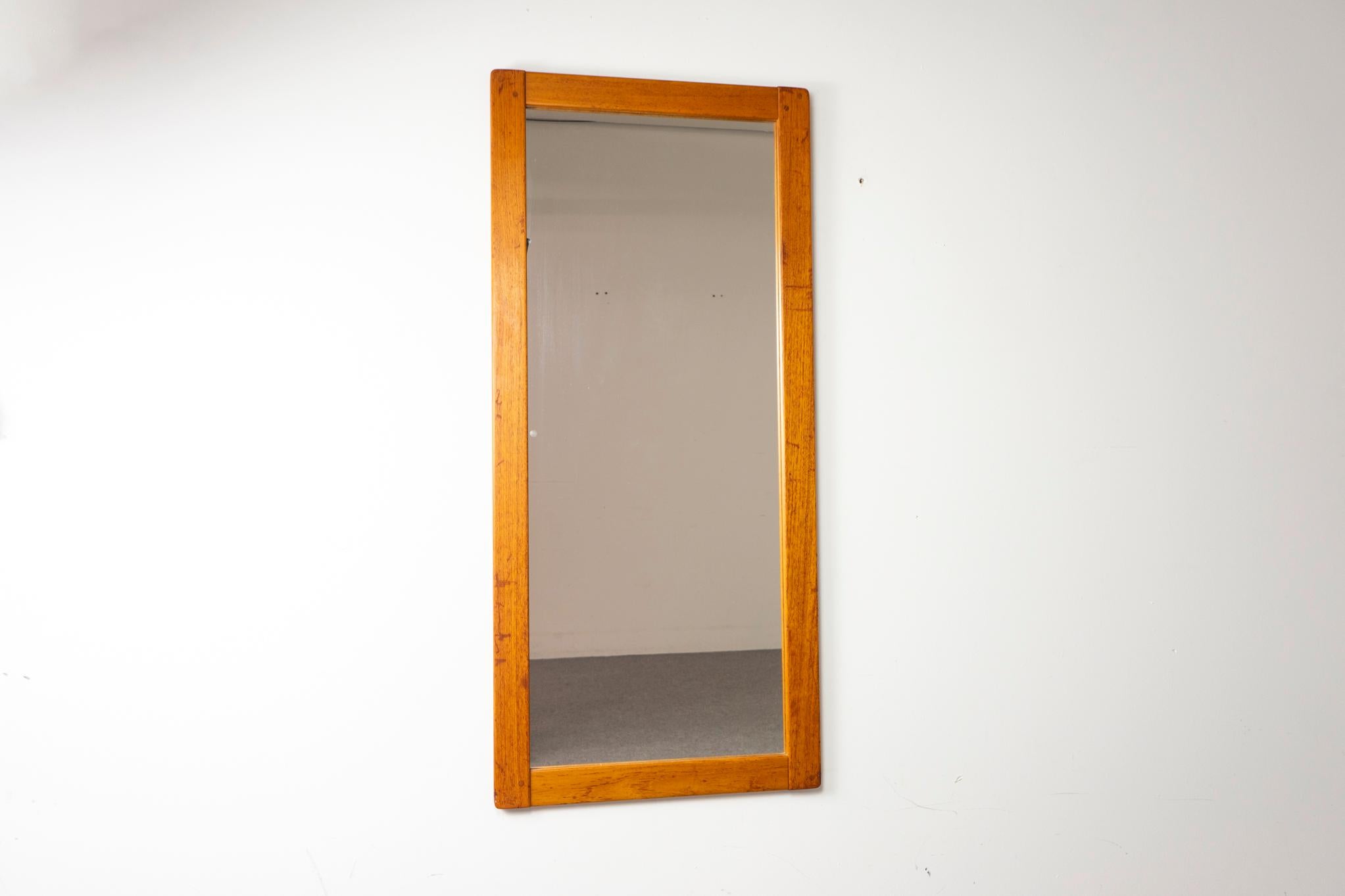 Miroir mural danois en teck du milieu du siècle dernier, vers les années 1960. Cadre solide au grain doré et verre neuf impeccable.

