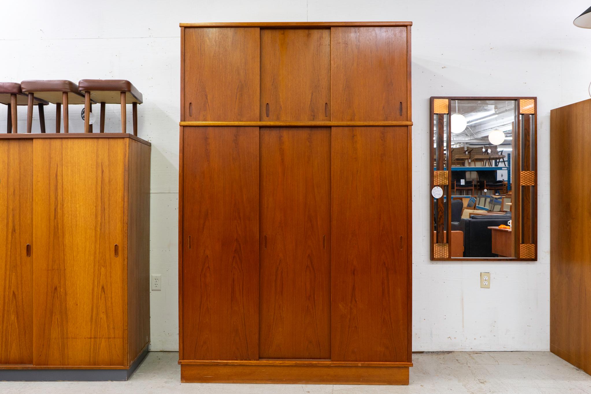 Teak Danish wardrobe, circa 1960's. Bookmatched teak veneer with sculpted inset pulls, cavernous storage compartment, clothes hanging bar and removable upper shelf. Flat packs for shipping.

Unrestored item with option to purchase in restored