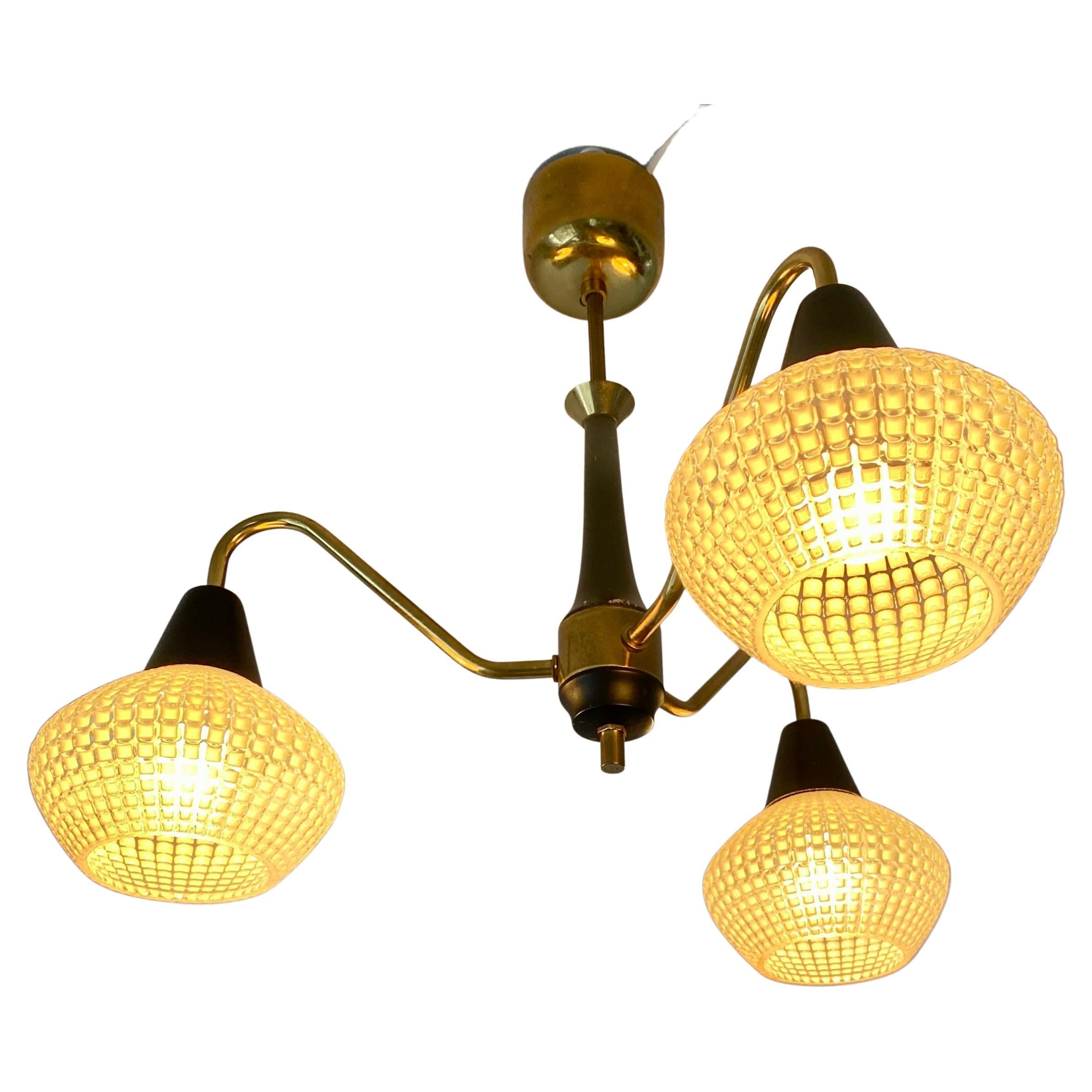 Mid-Century Modern chandelier in brass and black wood and with three glass shades, Denmark circa 1950's.

 