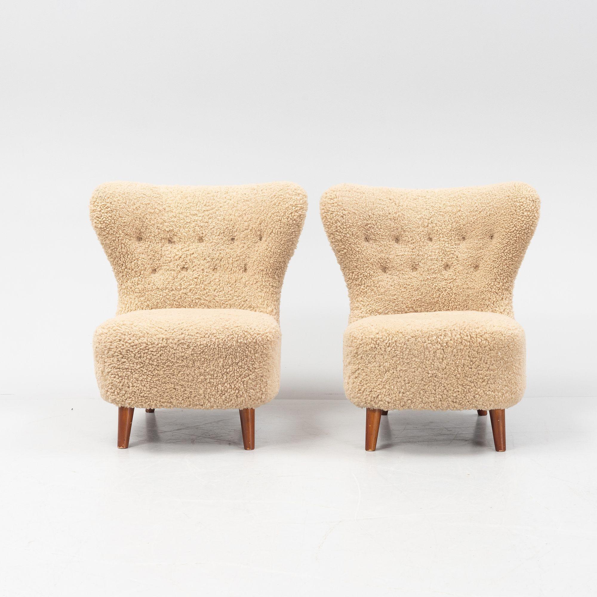Chic low-profile Danish cabinet maker lounge chairs in a later genuine sheepskin upholstery. These gorgeous chairs feature a tufted modernist form back and a chunky base, all sitting on four lacquered beech legs. These pieces are solid in form and
