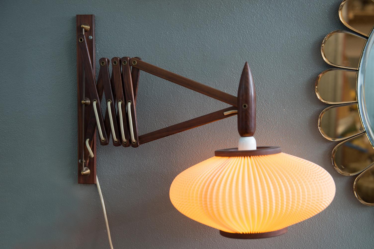 Dänische Mid-Century Modern ausziehbare Wandlampe aus massivem Palisanderholz.
Maße: B. 54 / 101 cm (offen), T. 30 cm.