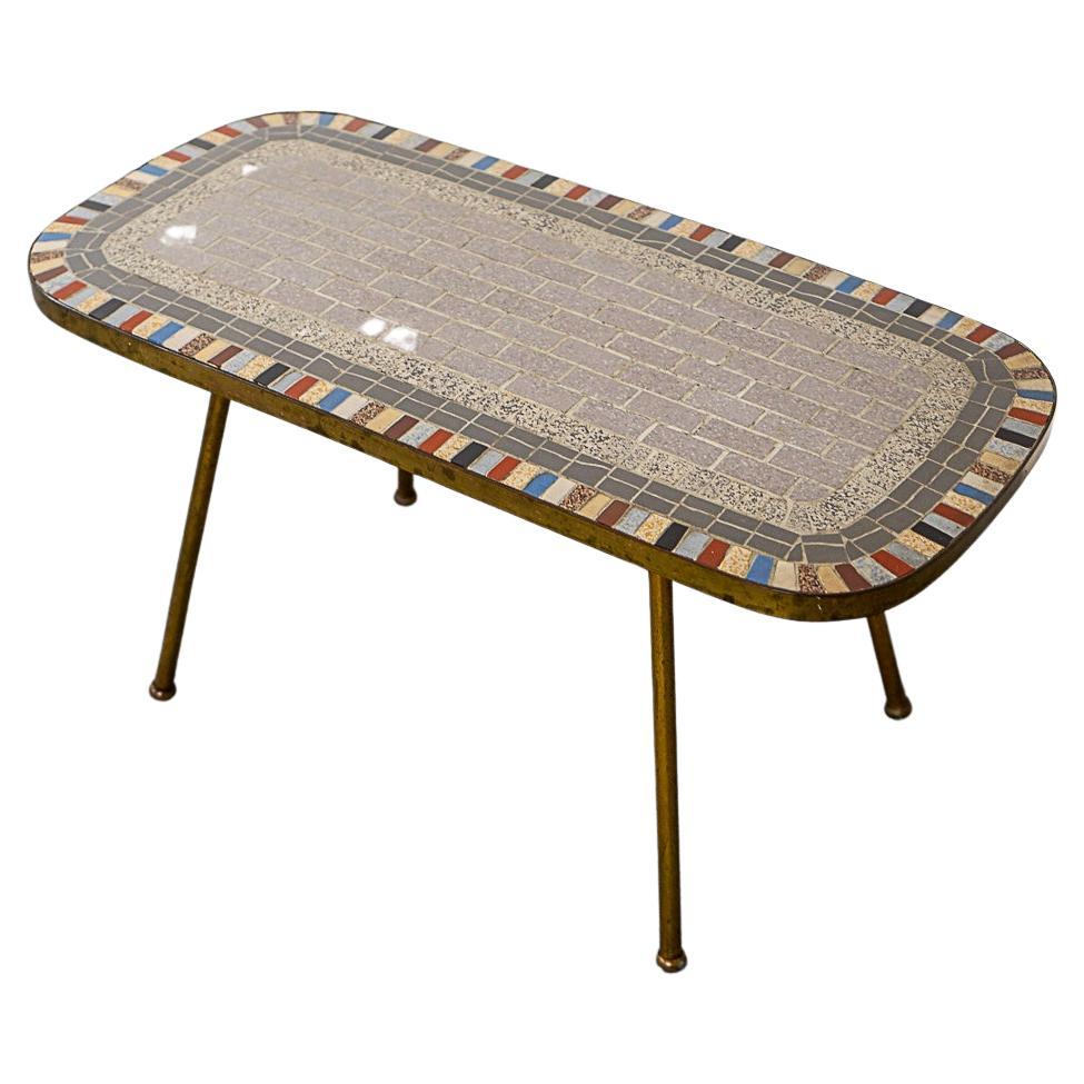 Table d'appoint en métal et céramique, vers les années 1960. Un cadre métallique élégant, des pieds évasés et un plateau en mosaïque unique et joyeux !