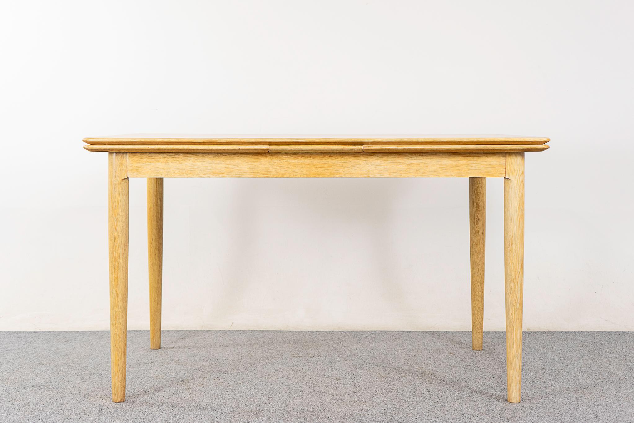 Oak Danish dining table by Skovmand & Andersen, circa 1960's. The blonde and beautiful! Edges are generously framed in solid wood, center panels are highly figured book-matched veneer. Self-storing draw leaves slide out to extend the surface by