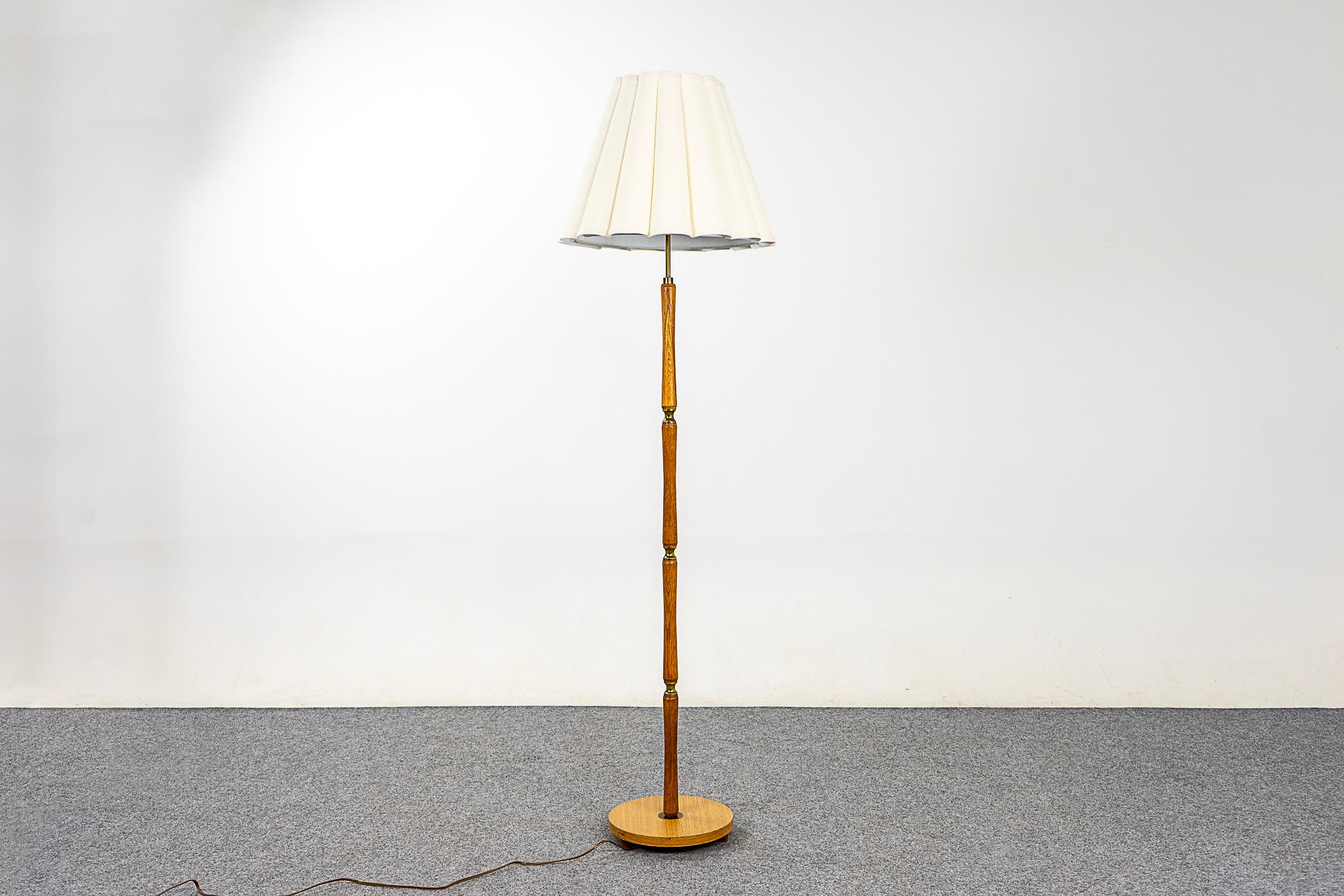 Teak Danish mid-century floor lamp, circa 1960's. Sold oak pole with veneer base and metal accents. Stunning custom scalloped fabric shade. New tri-light socket, adjust the brightness of the lamp to suit your mood. Rewired for 110V.

Please inquire