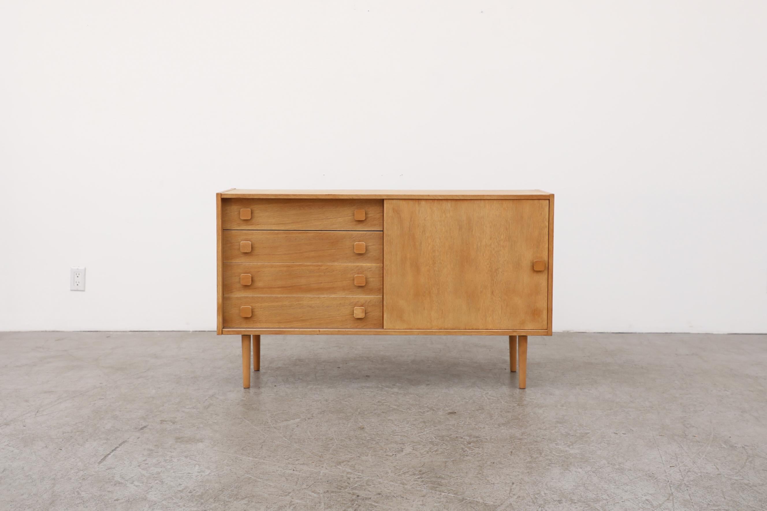 1970's Domino Mobler Danish oak sideboard or credenza with one sliding door and four drawers. Great example of Scandinavian design. This pieces has been sanded down for an unfinished light oak tone, it's in otherwise original condition with visible