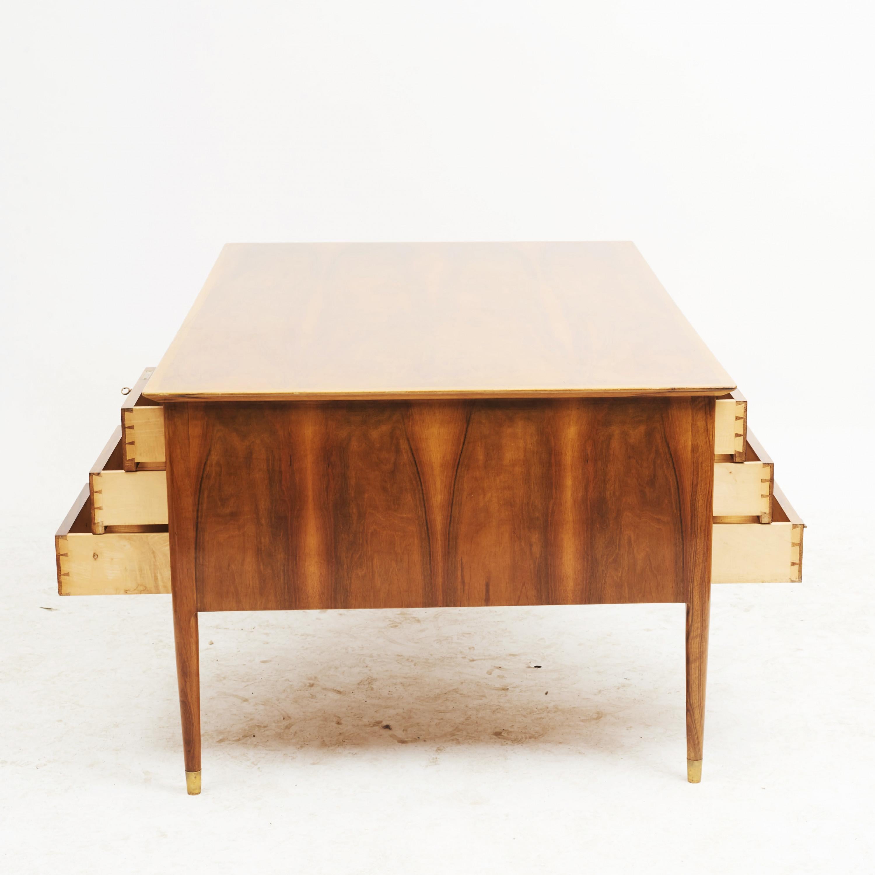 Ole Wanscher, 1903-1985. Desk / partner's desk in walnut veneer. Six drawers on each side with original brass hardware. Legs with brass feet.
Denmark, circa 1960.

Measurement (cm): H 74 / 67.5, B 165, D 100.
     
