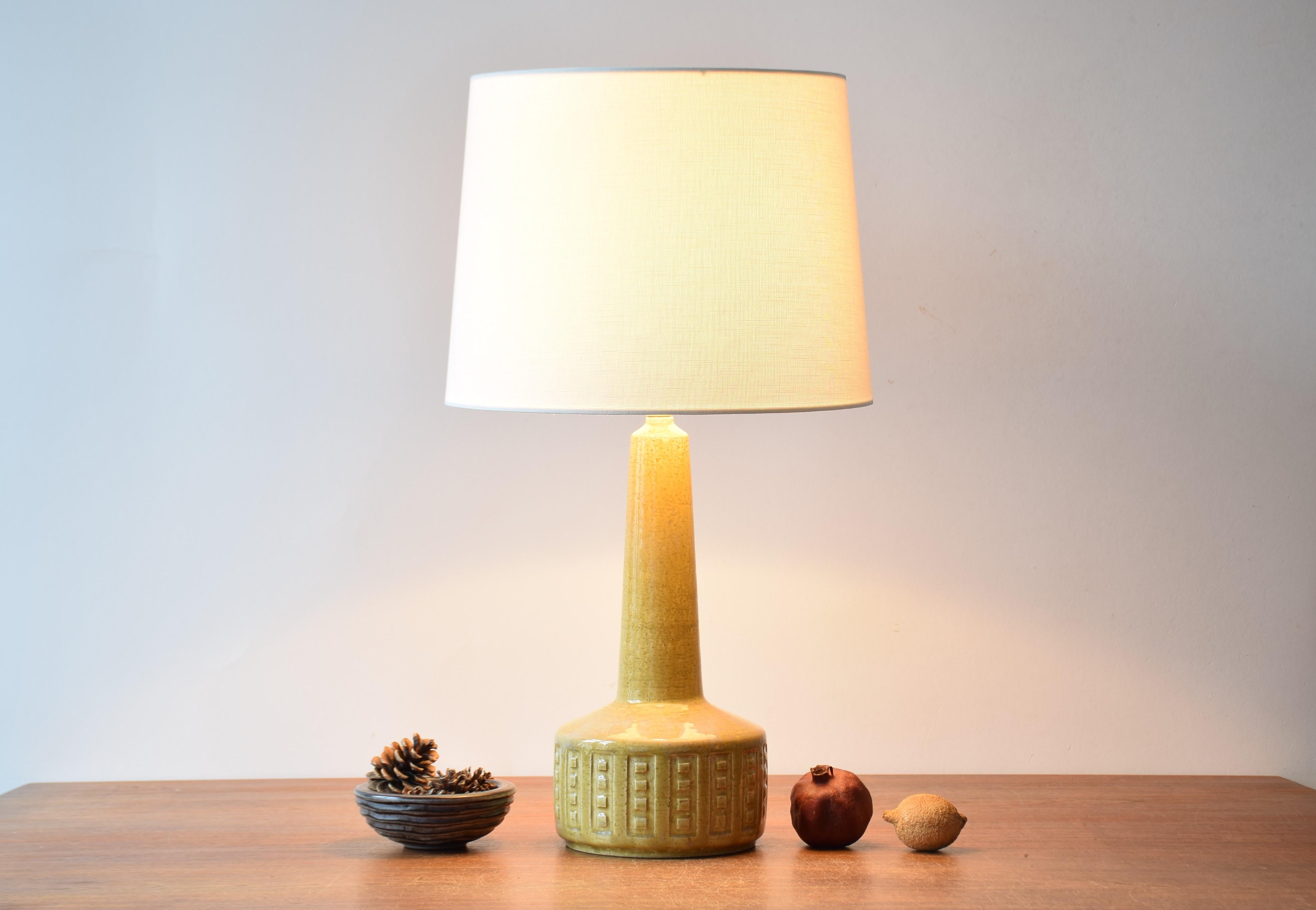 Tall midcentury Danish table lamp from Palshus.
The lamp was designed by Per Linnemann-Schmidt and manufactured circa 1960 or early 1970s.
It is made with chamotte clay which gives a rough and vivid surface. The glaze is yellow with pale blue