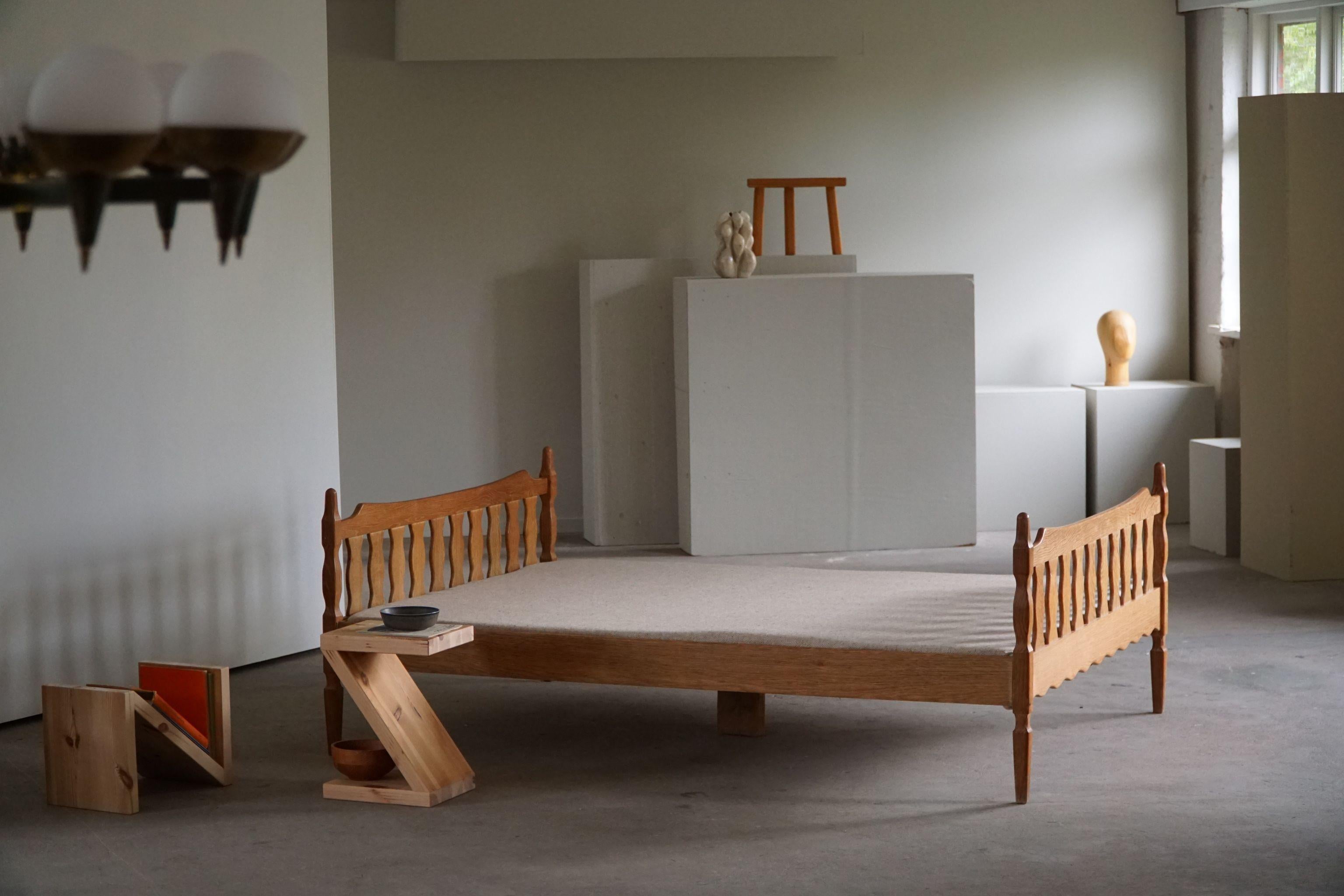 A rare double bed in solid oak with a newly made mattress. Designed by Henning Kjærnulf for EG Møbler, Denmark. A 