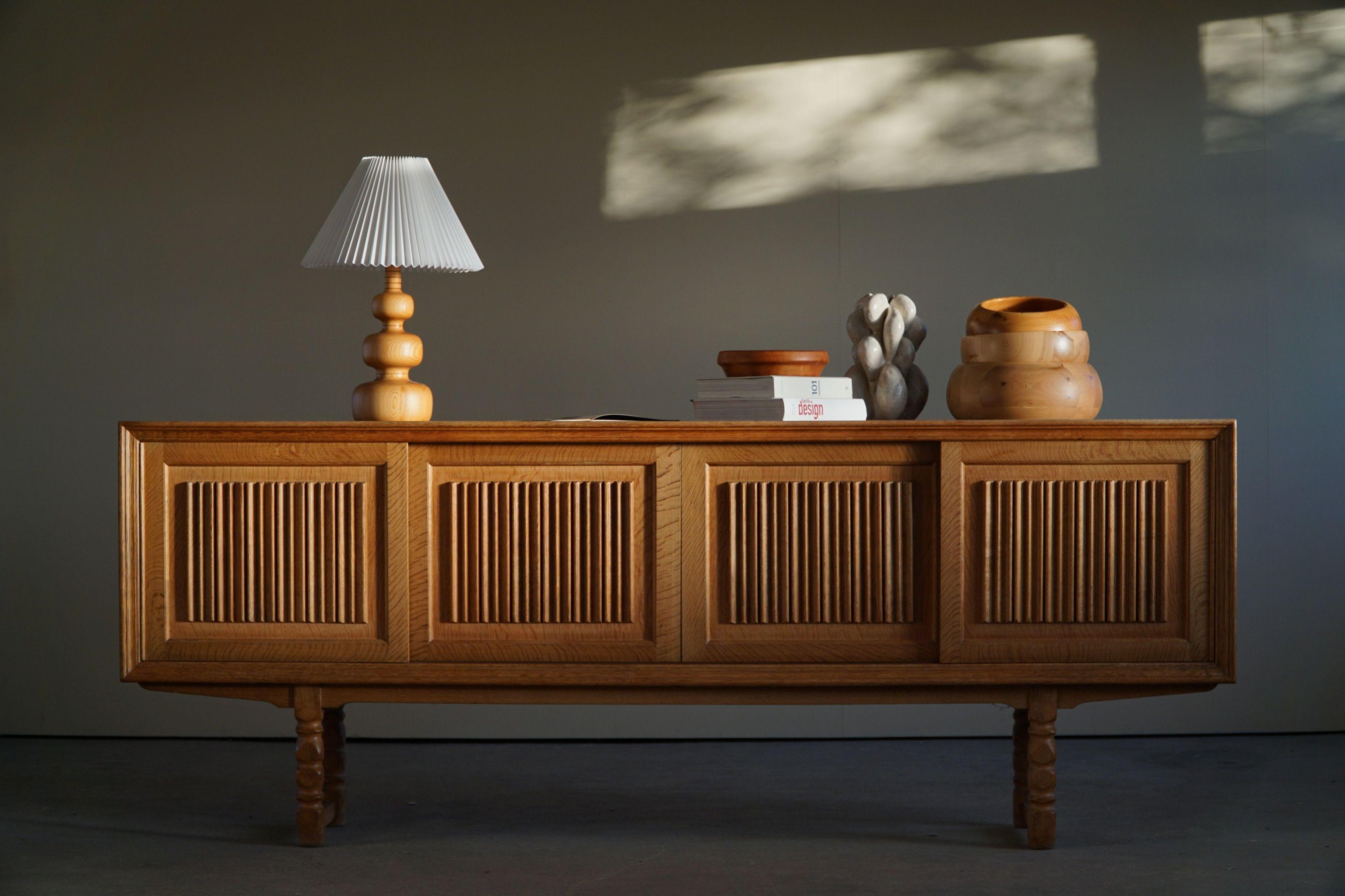 Danish Modern rectangular sideboard, made in oak, ca 1950s.

A great patina and a nice sculptural front design. 

With a heavy focus on functionality, this design style leans toward modernism, while incorporating coziness. The Scandinavian