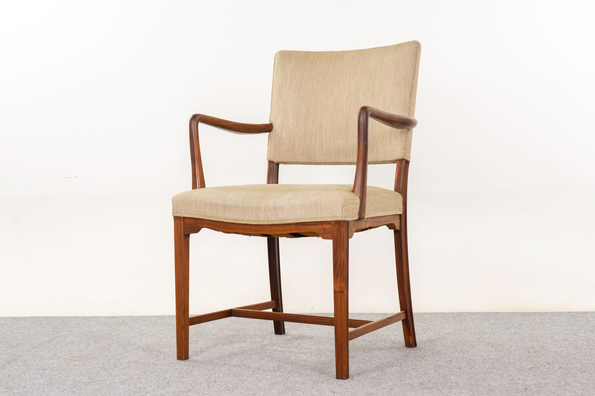 Poltrona danese in palissandro, anni '50 circa. La struttura è elegante e i braccioli sono deliziosi, mentre lo schienale imbottito offre supporto e comfort. Tappezzeria originale con usura. 