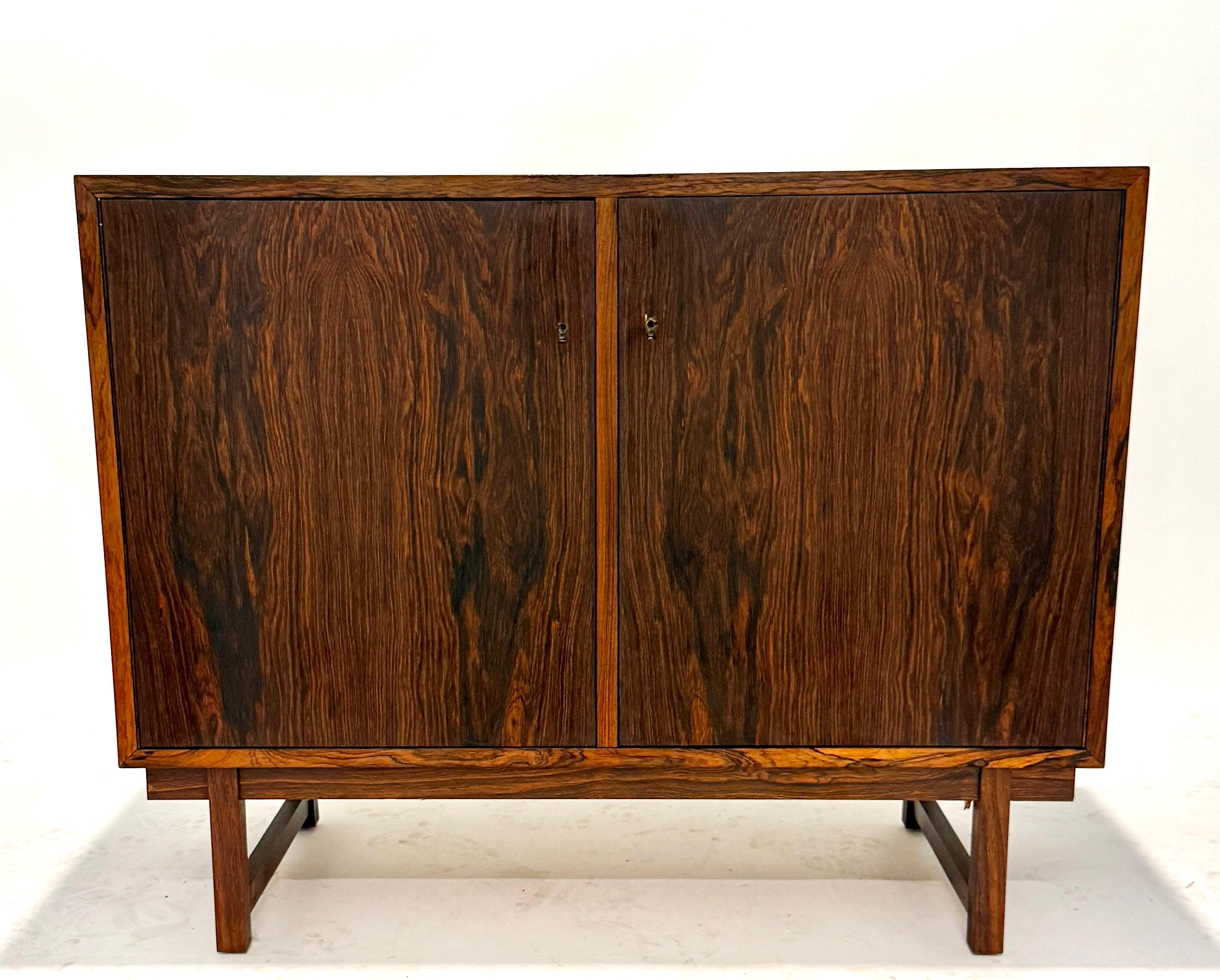 Un mobile moderno di metà secolo splendidamente realizzato da Riis Antonsen in Danimarca. Realizzato in legno di palissandro riccamente scolpito, il mobile mette in risalto i sorprendenti motivi delle venature naturali, accuratamente abbinati a