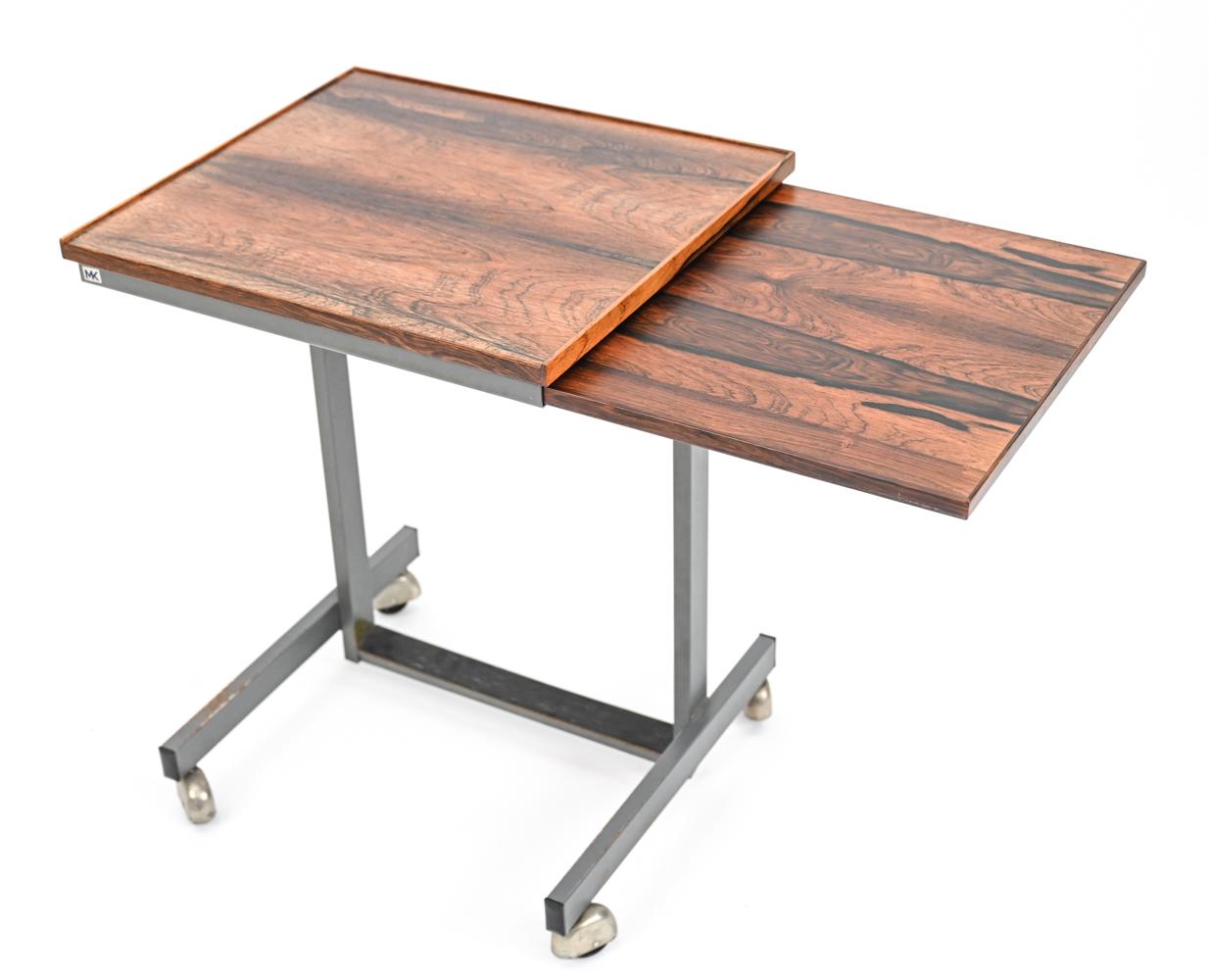 An unusual Danish mid-century child's-scale diminutive desk featuring a fine rosewood top with pull-out writing surface and metal base on casters. With MK label to side edge underneath top. A charming piece for use in a child's room or for use as a