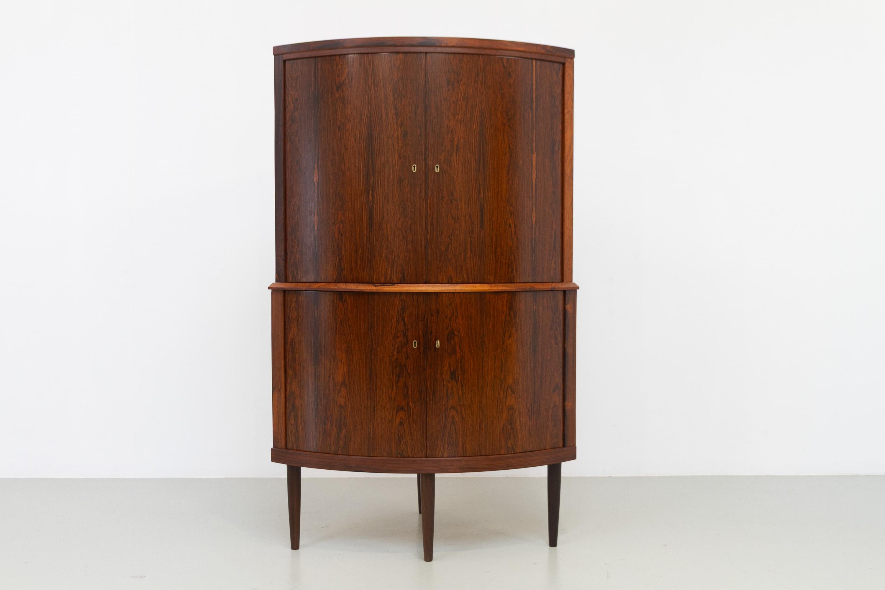 Meuble d'angle danois en palissandre du milieu du siècle avec façade incurvée, années 1960.

Très belle armoire d'angle The Modern Scandinavian Mid-Century Modern à façade arrondie. Quatre portes à charnières avec serrure, clé incluse. A l'intérieur
