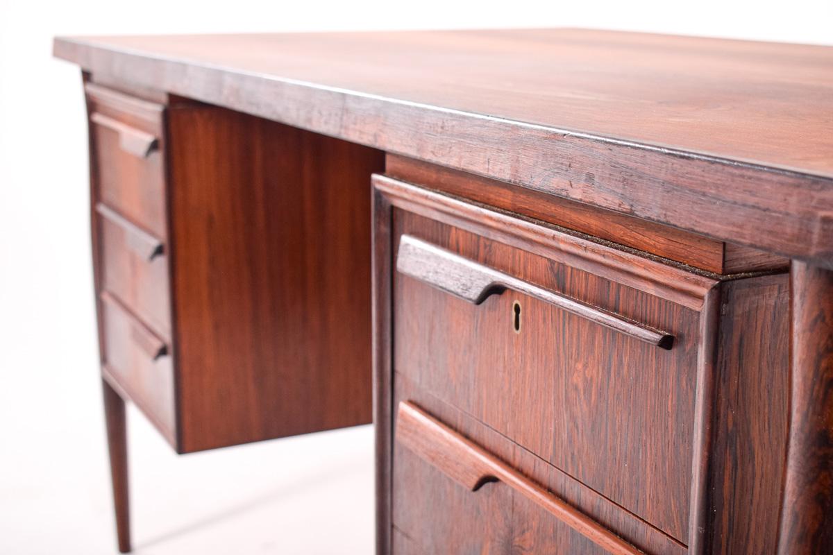 La belle couleur bois de rose de ce bureau est exceptionnelle. Grain de bois de rose frappant tout au long de cette pièce. Ce bureau conçu par Arne Vodder pour Sibast comporte trois tiroirs de chaque côté et deux armoires à l'arrière, avec des