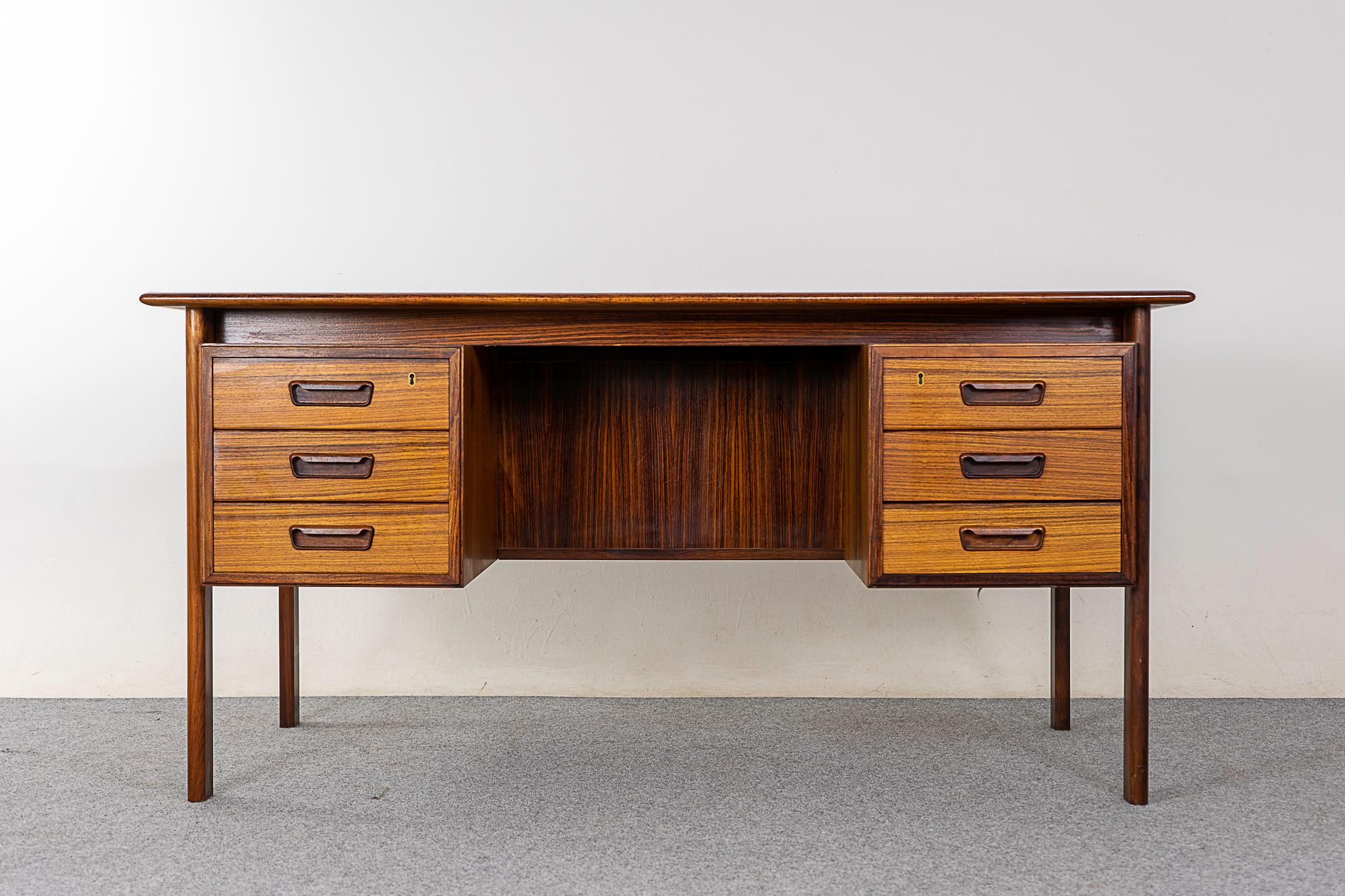 Rosewood mid-century desk by H. Sigh & Son, circa 1960's. Stunning bookmatched veneer top surface, beautiful carved handles and plenty of storage. Open cubbies on the finished back, generous knee opening for executive office chairs! H. Sigh & Son