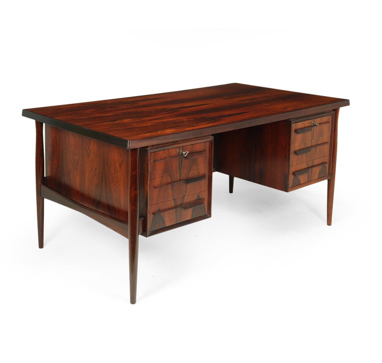 An exceptional quality rosewood desk produced in Denmark in the 1960’s attributable to the work of Kai Lyngfeldt Larsen, with solid rosewood frame and edging as if to imitate a floating top, it has 6 drawers having stylish handles, the two top