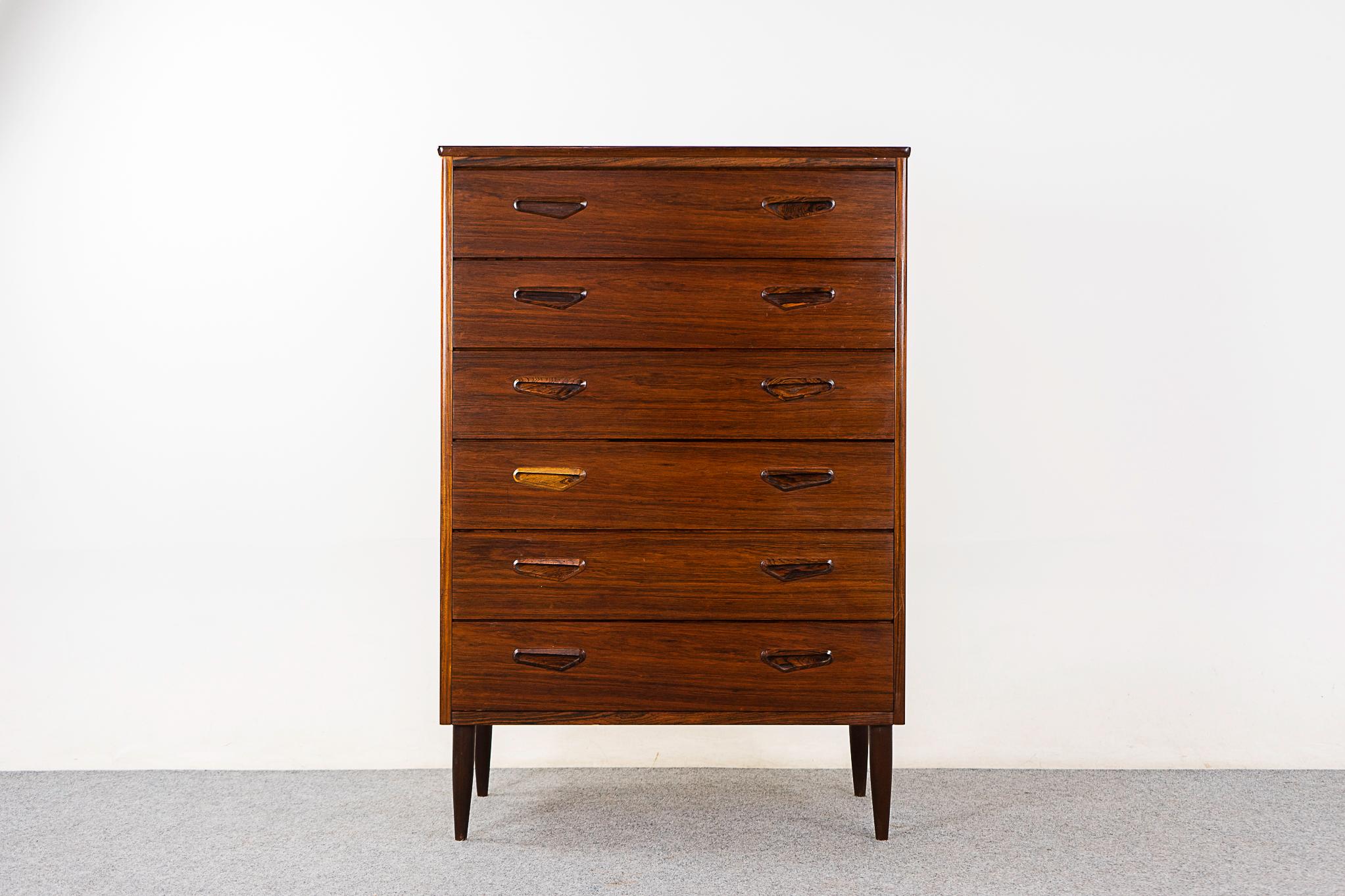 Rosewood mid-century dresser, circa 1960's. Solid wood edging with stunning book-matched veneer. Dovetail constructed drawers with stylish handles, elegant tapering legs.

Please inquire for international and remote shipping rates. 