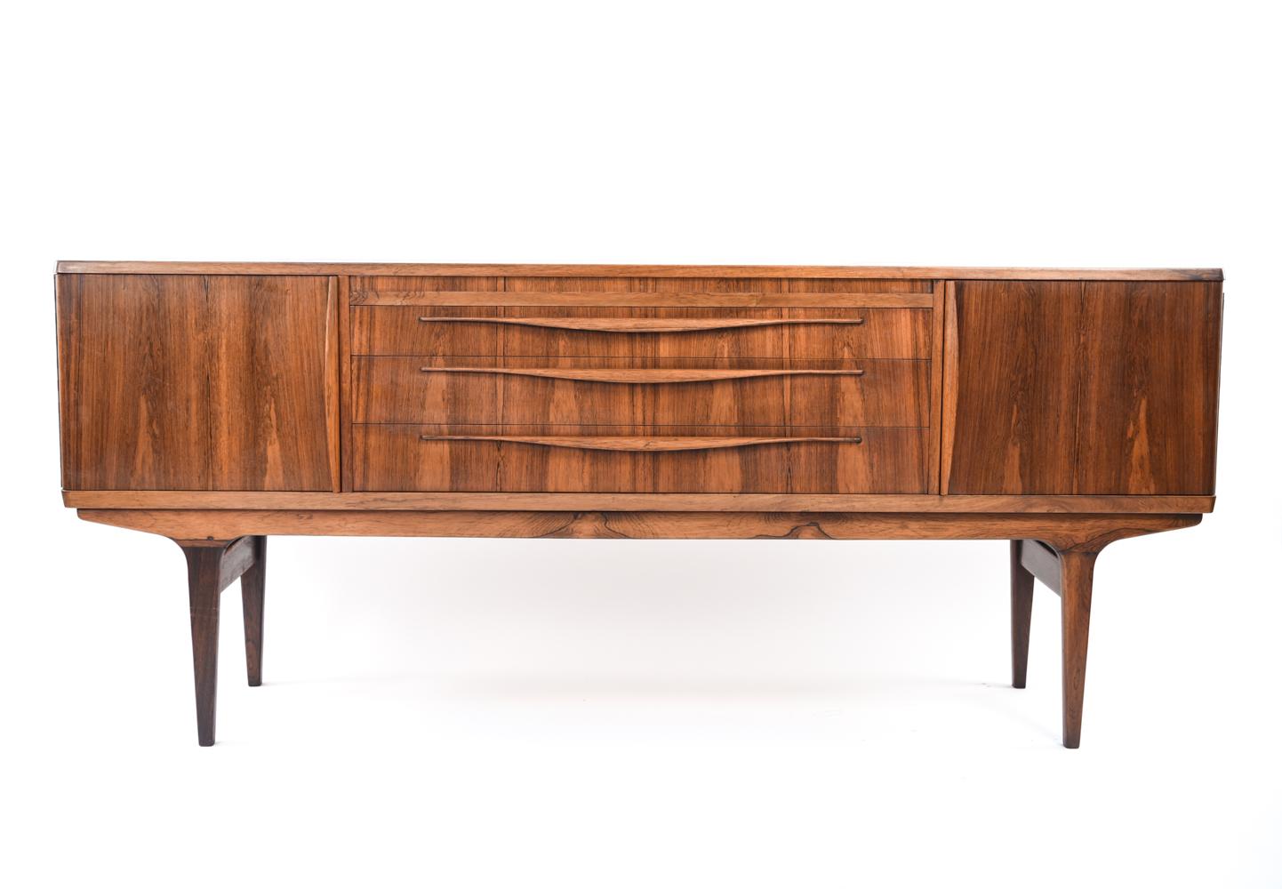 This piece is a Classic example of Danish midcentury design. Three central drawers are flanked by cabinets, providing ample storage. The rich color of the rosewood elevates this piece to the highest of standards.
