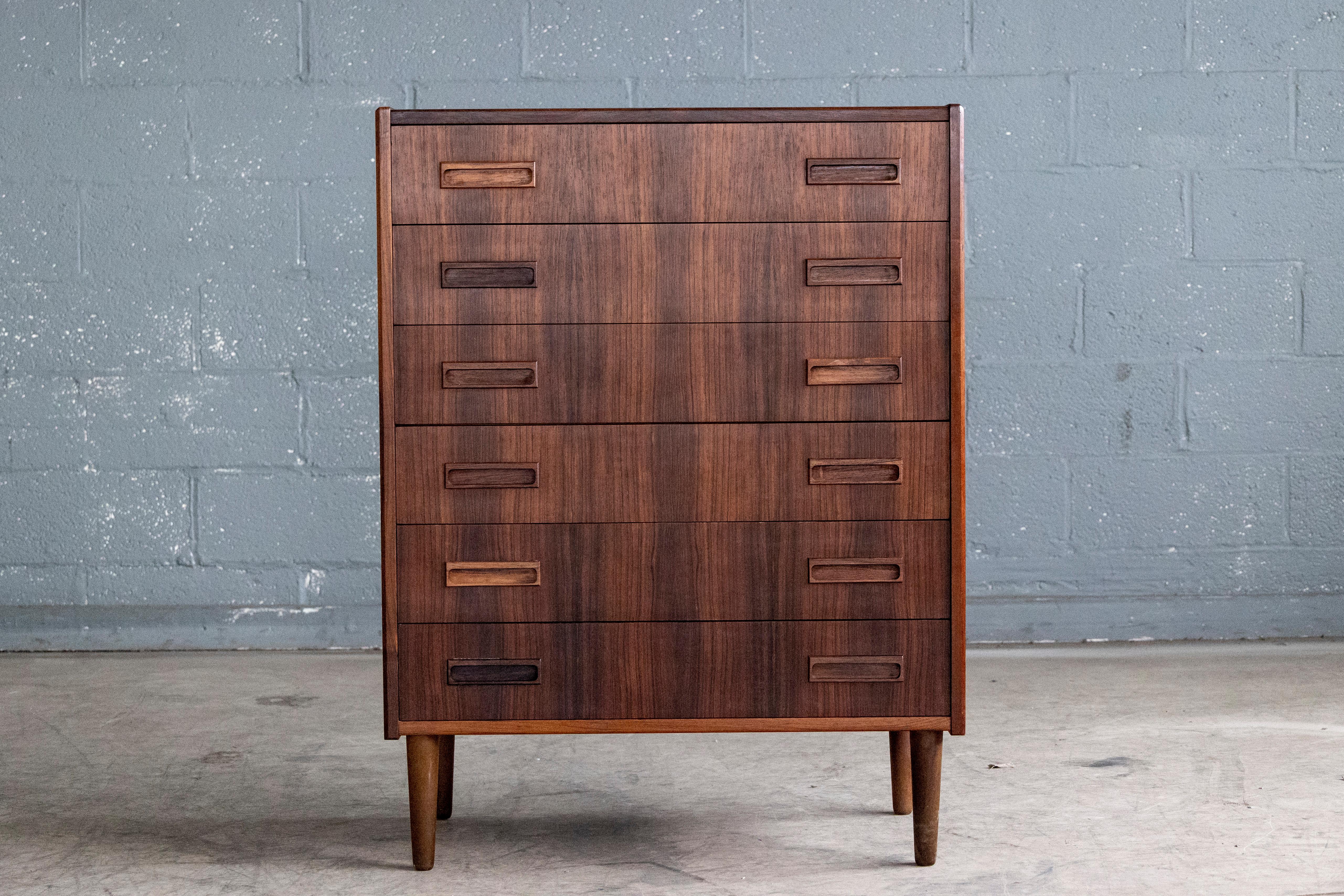 Exquisite Danish 1960s rosewood chest of drawers with six large drawers in bookmatched rosewood veneer. High quality craftmanship with solid edges and carved drawer pulls. Drawer fronts made from solid ply and assembled with dove tailing. Unmarked.