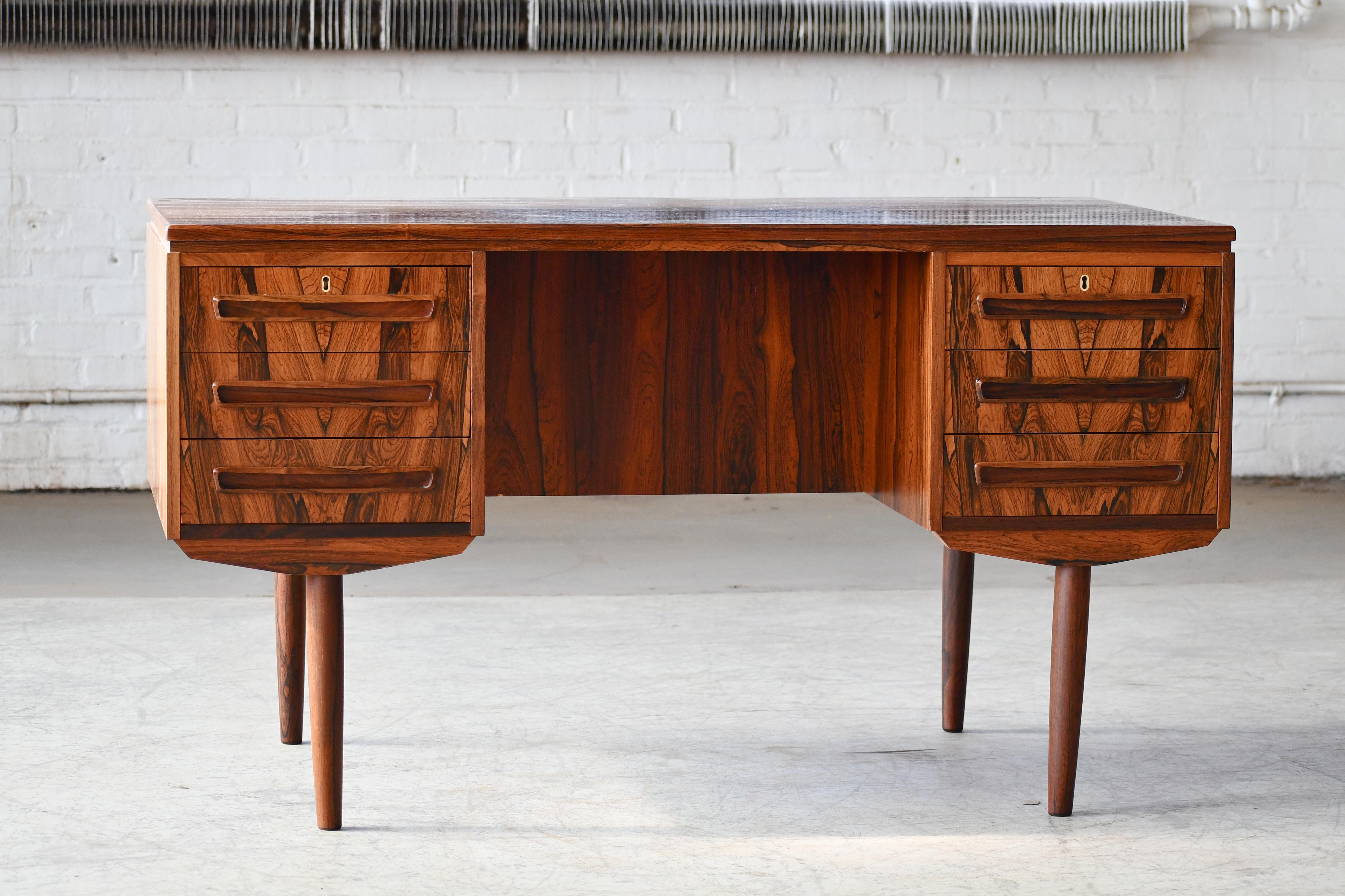 Beautiful Danish small executive desk in the style of ai Kristiansen and made of rosewood in Denmark sometime in the late 1950s or early 1960s by J. Svenstrup Mobler. This desk is slightly smaller than a traditional executive desk and fits well in