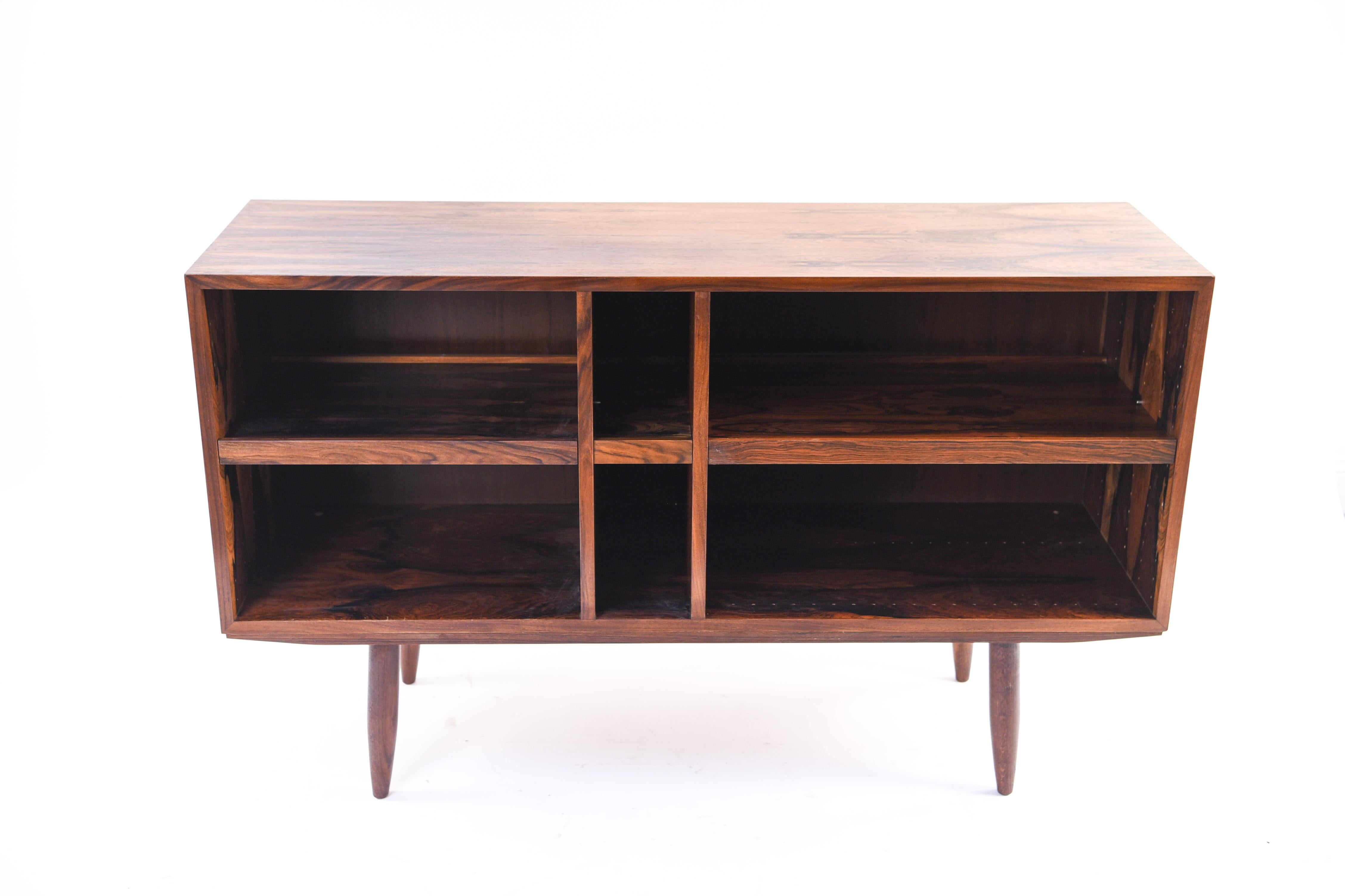 This open-faced Danish midcentury stereo cabinet could double as a storage or display piece with its compartmentalized interior. The body of the cabinet sits upon sturdy, turned legs, characteristic of Scandinavian Modern design. The rosewood gives
