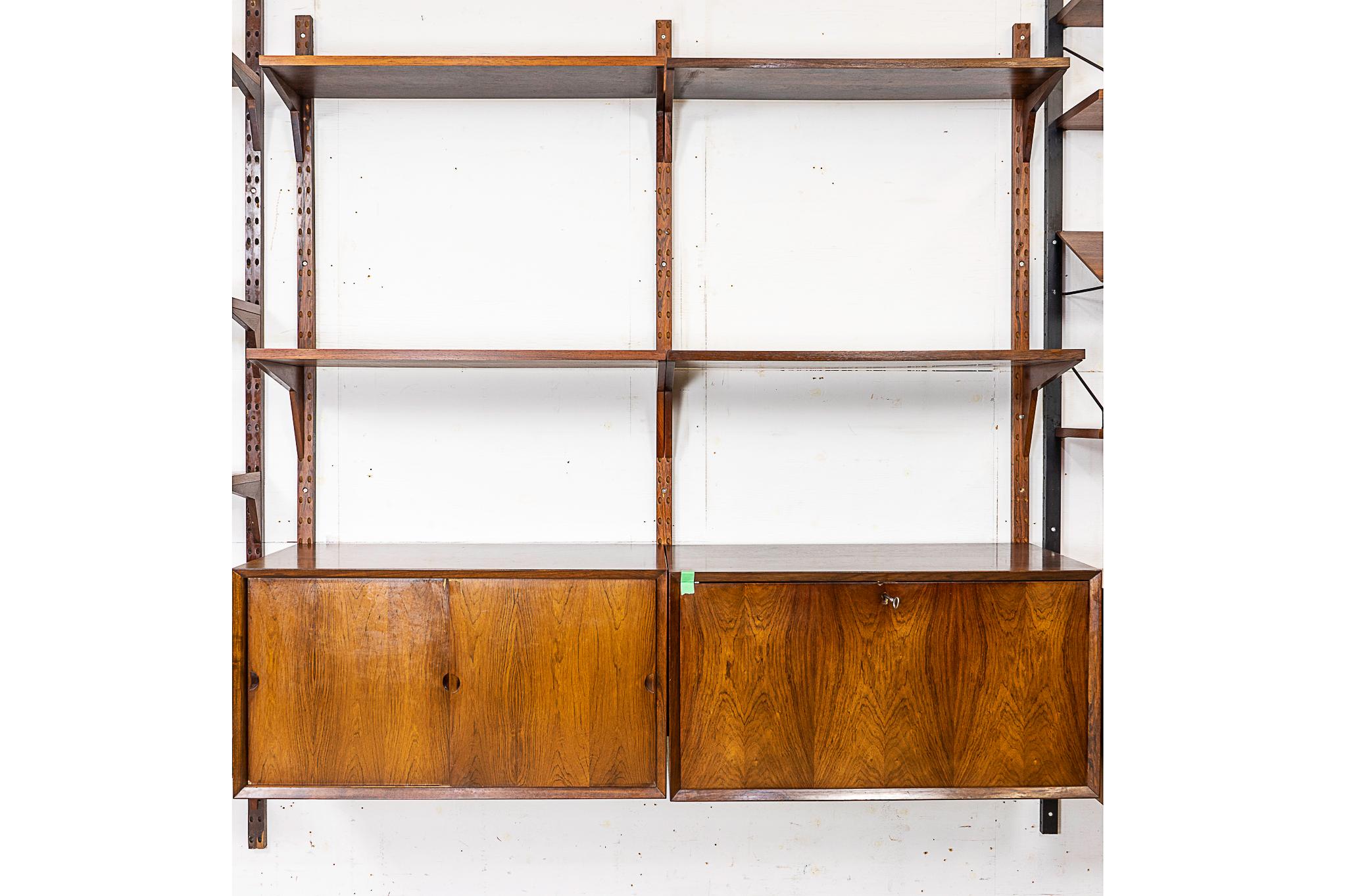 Danish Mid Century rosewood wall system, circa 1960's. Modular cabinetry and shelving make this versatile wall system the perfect solution for home or office use where space is limited but function is a high priority. System includes 4 shelves, a