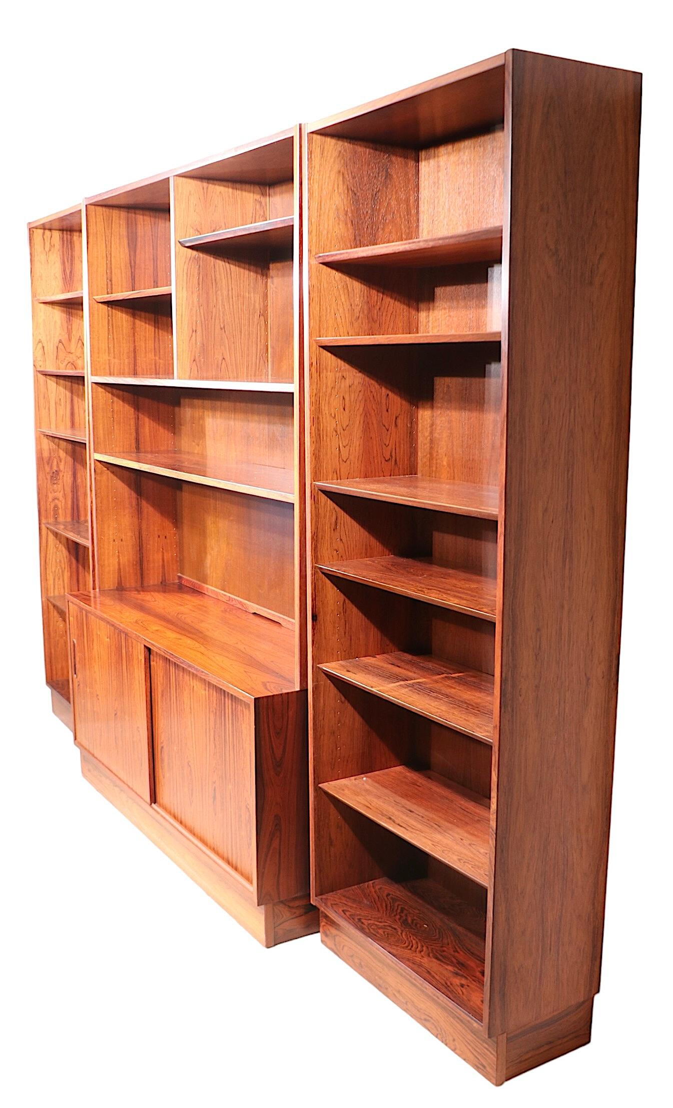 Spectacular  Mid Century Modern bookcase wall unit designed by Poul Hundevad, made in Denmark c 1960's. The wall unit consists of three separate freestanding cabinets, two smaller side pieces, and the larger middle section.  Middle section features