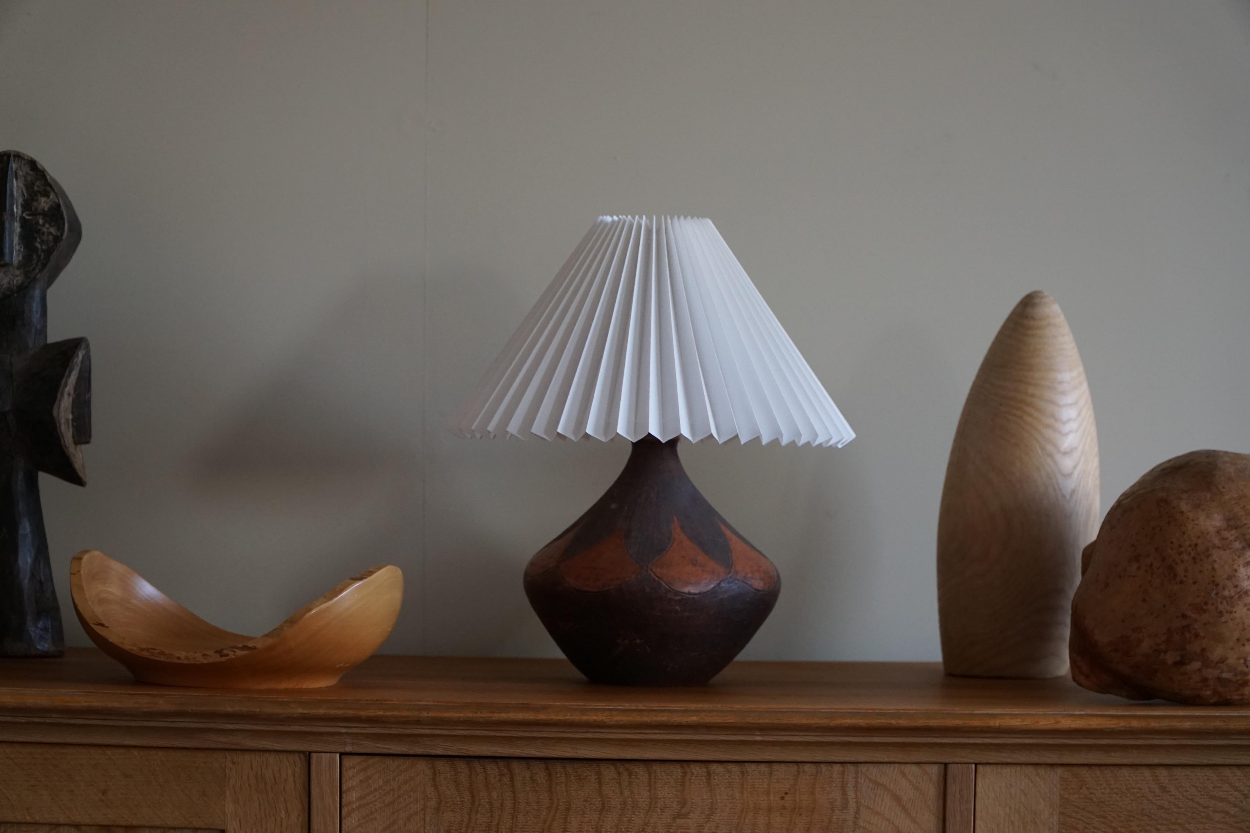 A fantastic mid-20th century round ceramic table lamp with beautiful patterns in various orange/brown colors. Made in Denmark in the 1950s. A beautiful shape that make it well suited for the Modern interior or Scandinavian lifestyle.

NB: Doesn't