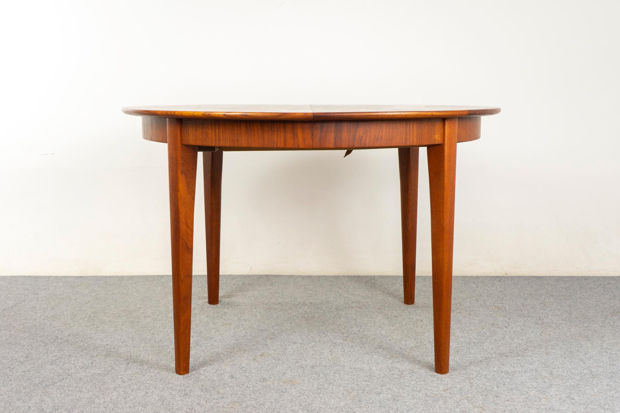 Table de salle à manger danoise en teck par Henning Kjaernulf, vers les années 1960. Placage et chants massifs assortis au livre. Forme circulaire douillette avec 3 feuilles, s'allongeant au besoin ! Le tablier élégant se poursuit sur une des