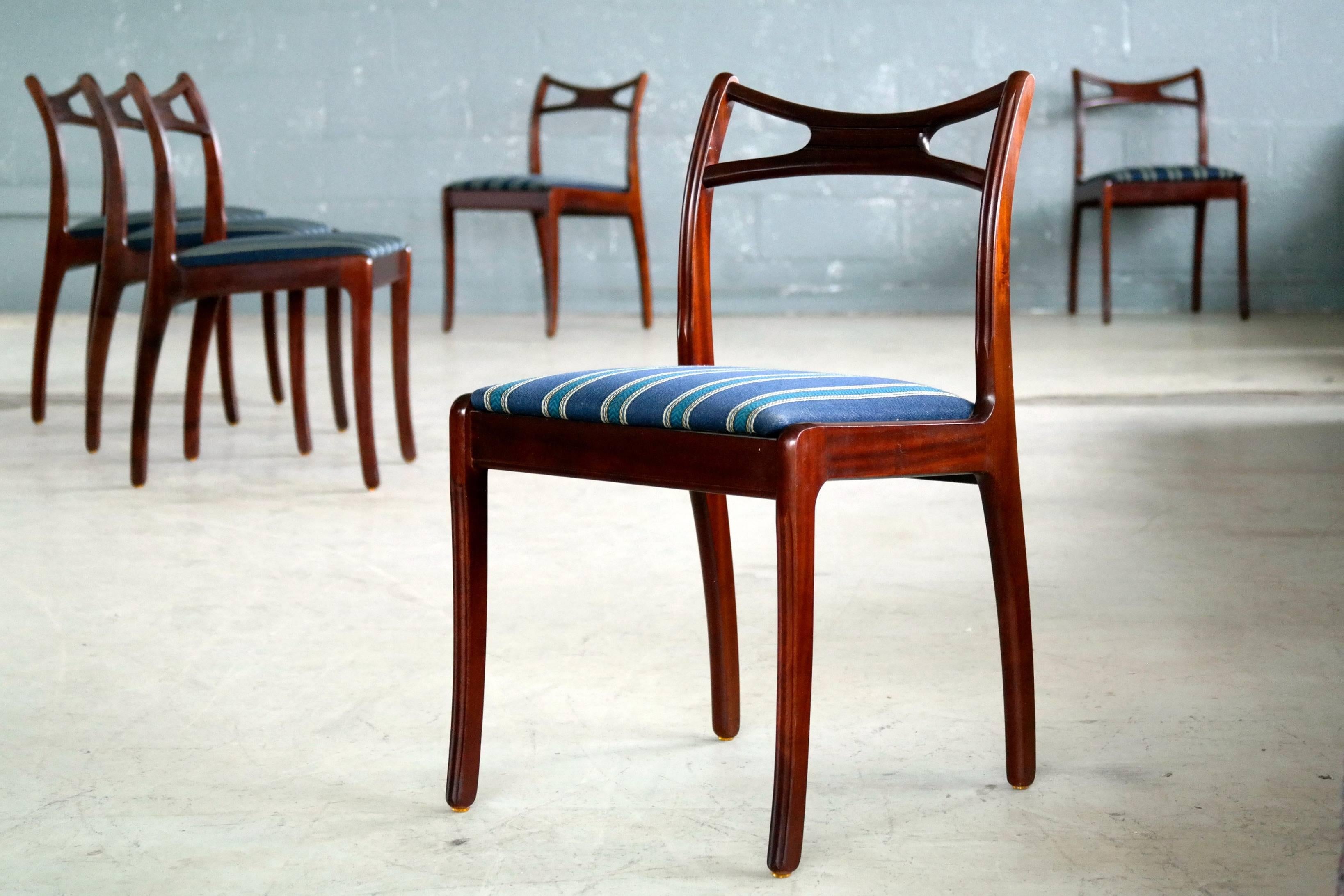 Very stylish 1950s Danish dining chairs in mahogany. Style reminiscent of Ole Wanscher's Rungstedlund chair. An interesting design element is the bayonet fluted front legs a design that is continued on the back support. Nice deep color and grain