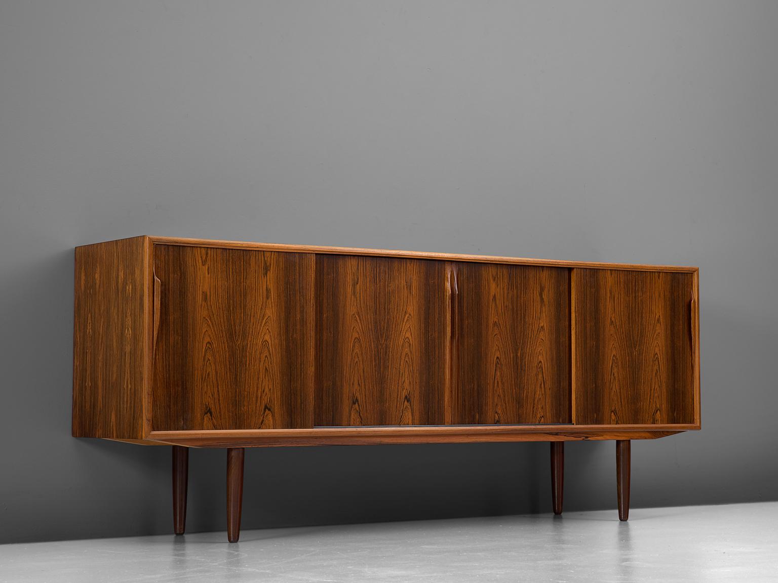 Sideboard, in rosewood, Denmark, 1960s.

This highly refined credenza has a modest and well proportioned design, showing extraordinary rosewood veneer. The four sliding doors have an interesting mirrored pattern of a lively grain. The contrasting