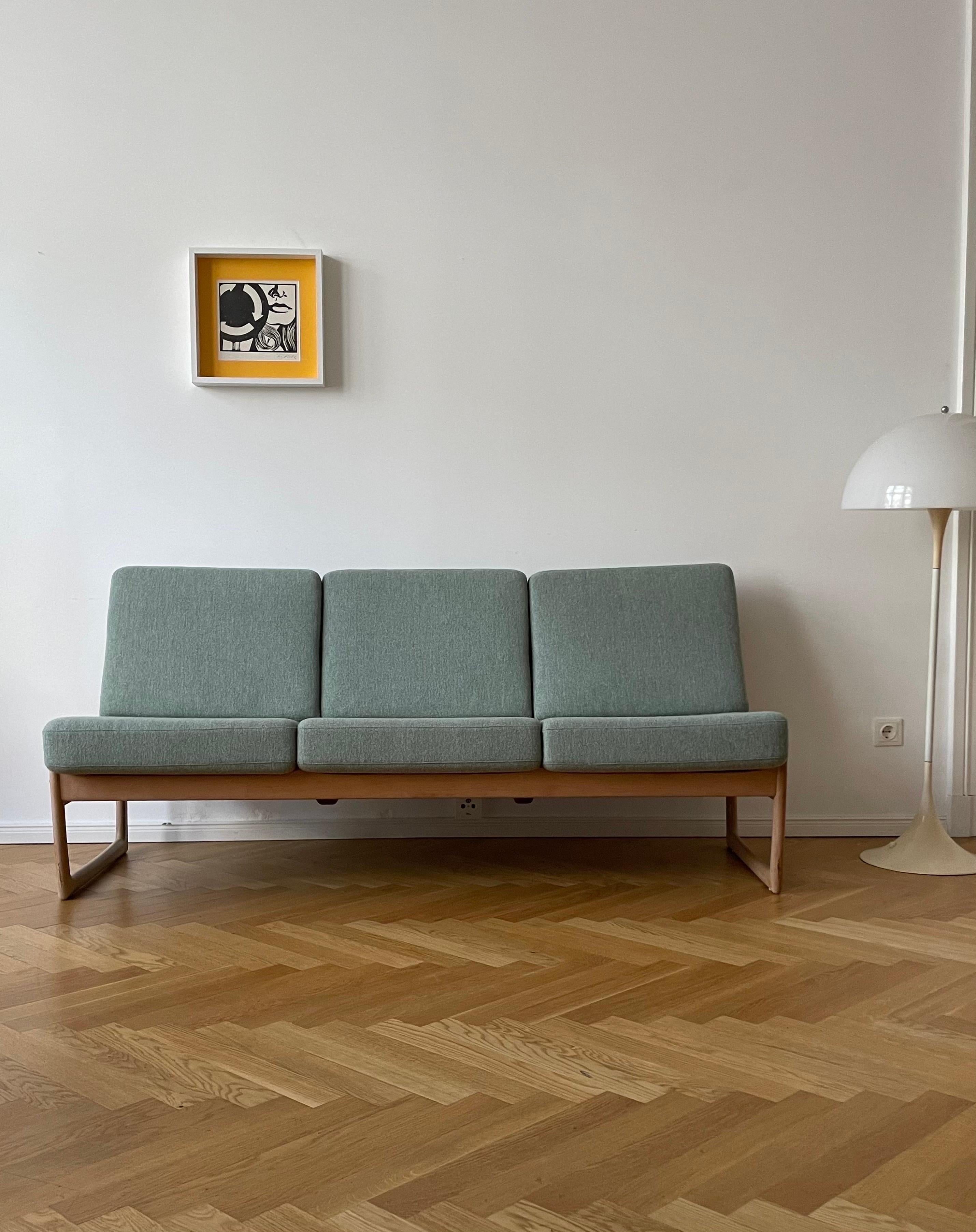 A comfortable 3seater sofa and daybed designed by Danish architects Peter Hvidt & Orla Mølgaard Nielsen. Made in Denmark by France & Daverkosen during the 1950's. This model FD130/3 features a compact size with a wooden frame in oak with a new