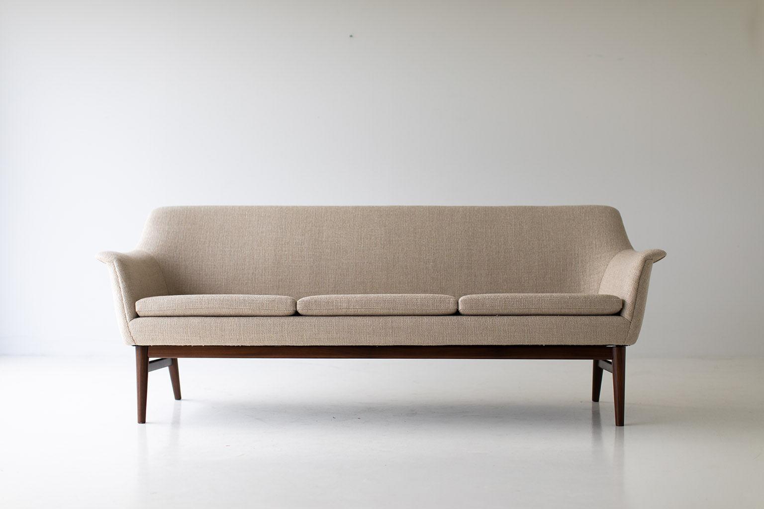 Designer: Unknown. 

Manufacturer: Unknown.
Period or model: Mid-Century Modern.
Specs: teak, commercial grade fabric. 

Condition: 

This mid century sofa in excellent restored condition. The sofa was originally purchased in Denmark and has