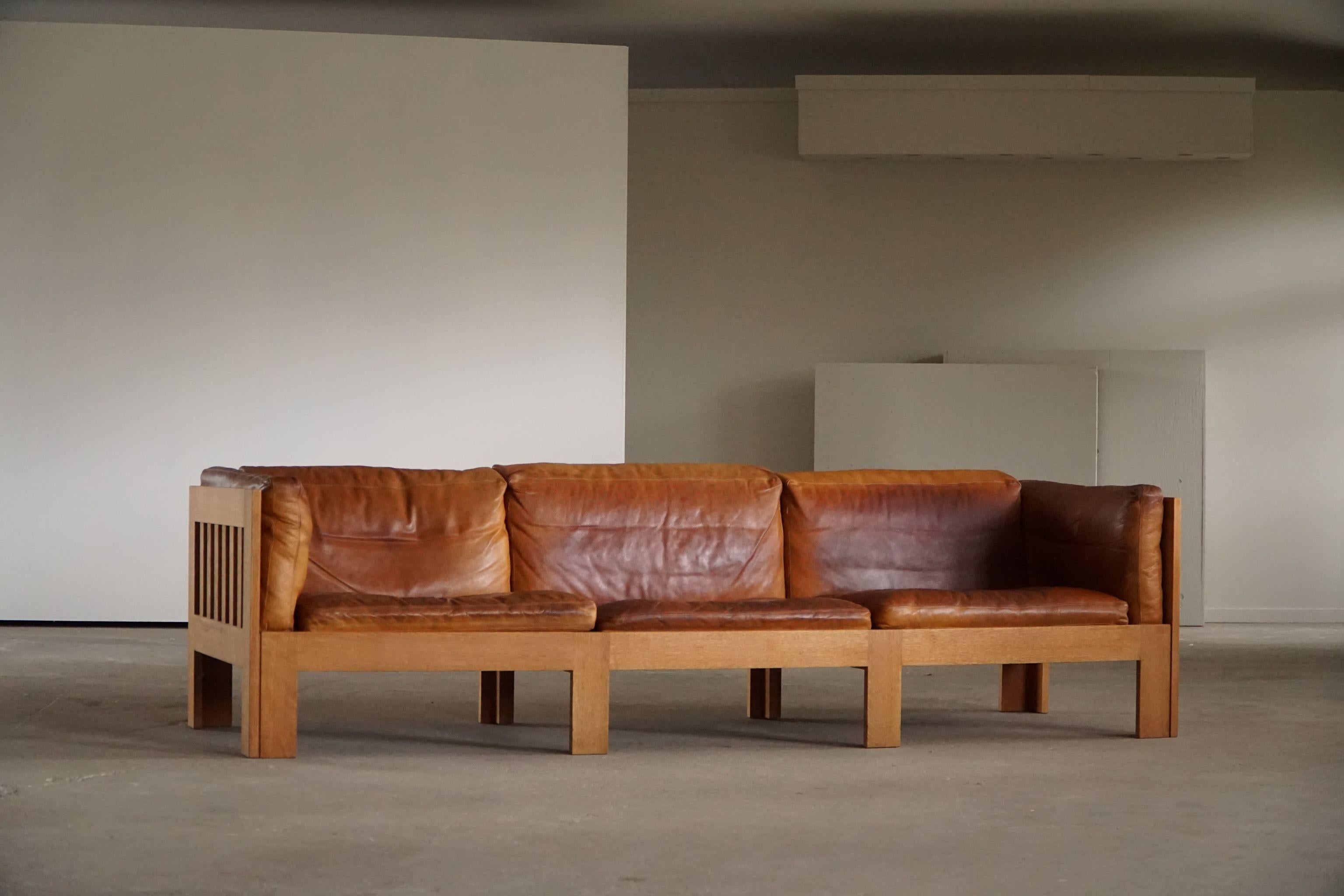 Lovely 3 seater sofa in oak with nice warm patinated leather cushions. Designed by Danish architect Tage Poulsen, model TP632. Designed in 1962. 

This sofa can be freestanding and fit any kind of interior style. From a Classic home to a