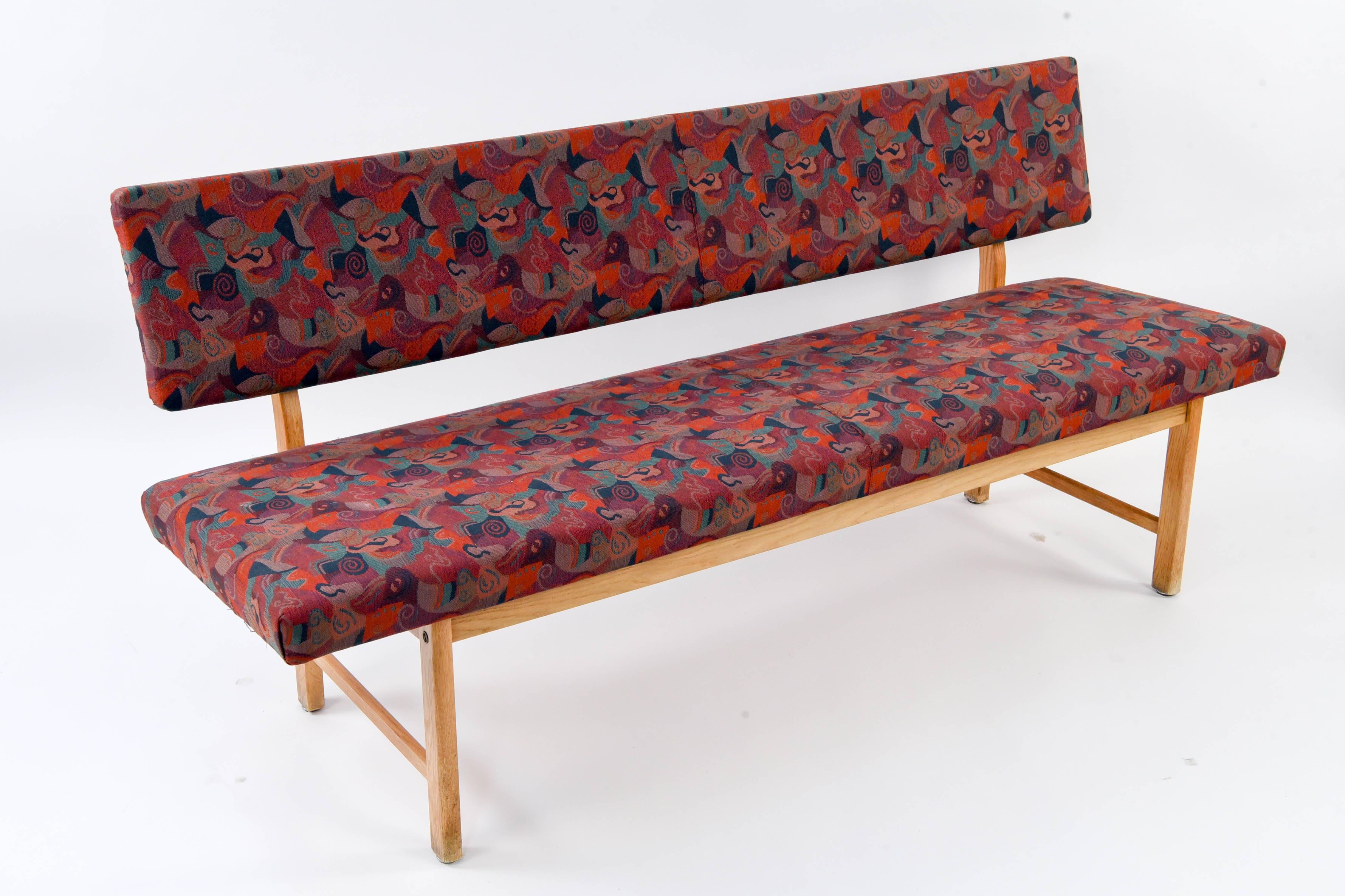 This Danish midcentury bench features retro upholstery t1hat could be kept or changed to fit the aesthetic of any living space. Has a great shape made of oakwood.