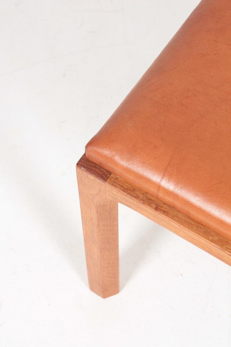 Stool in oak with seat in patinated leather. Designed by Kai Kristiansen for Aksel Kjærsgaard, made in Denmark, 1950s.
 