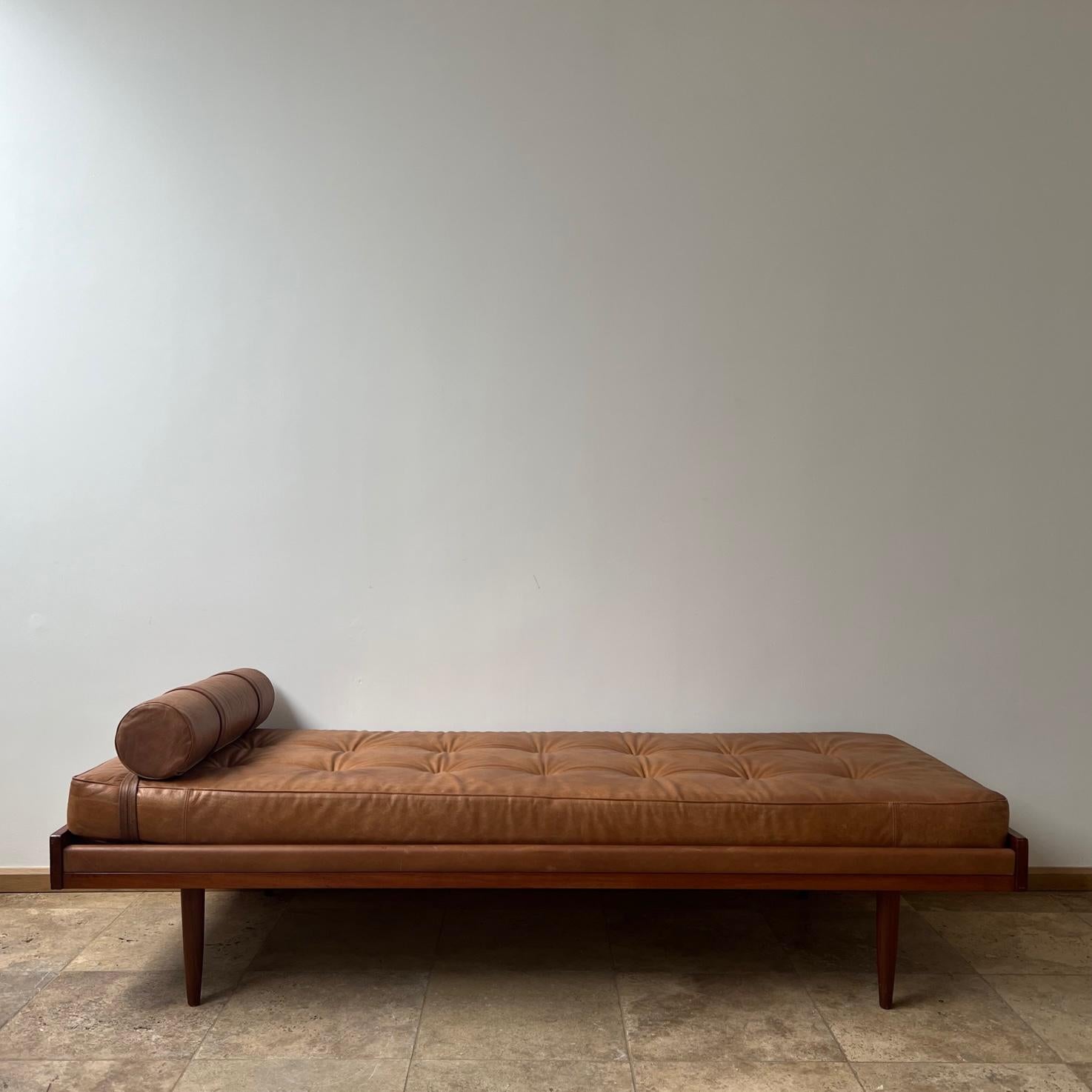 A teak and tan leather day bed. 

Denmark, c1960s. 

An elegant day bed in good condition, the leather strips to the side add a nice touch so there is a nice balance of wood and leather. 

Comfy, with a good patina, ready to go. 

Location: