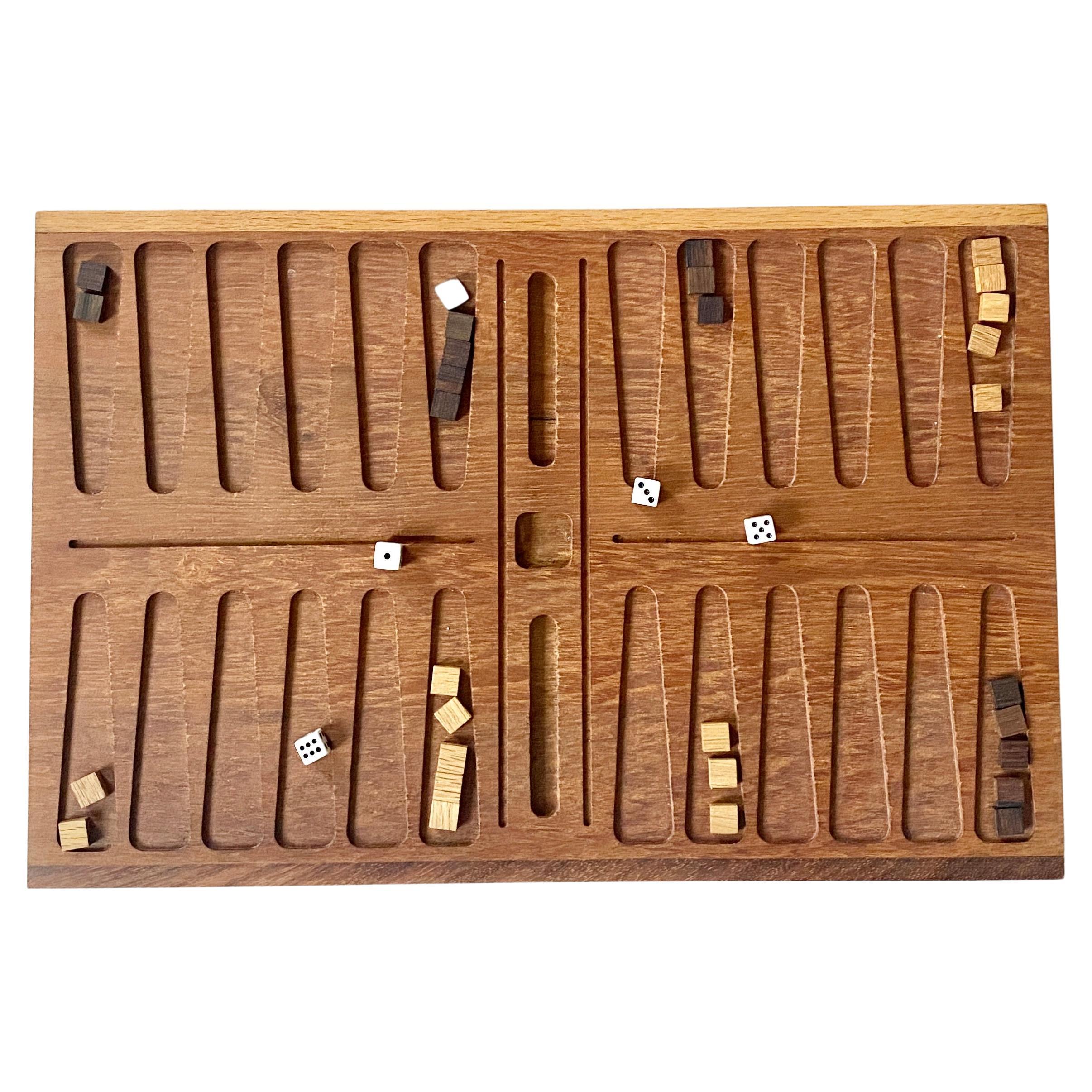 Vintage Backgammon set by Henning Bang made in Denmark. 

The Backgammon set is a solid teak board with 30 playing pieces. The set comes in its original box, with the original four dices and the original leaflet with the rules are