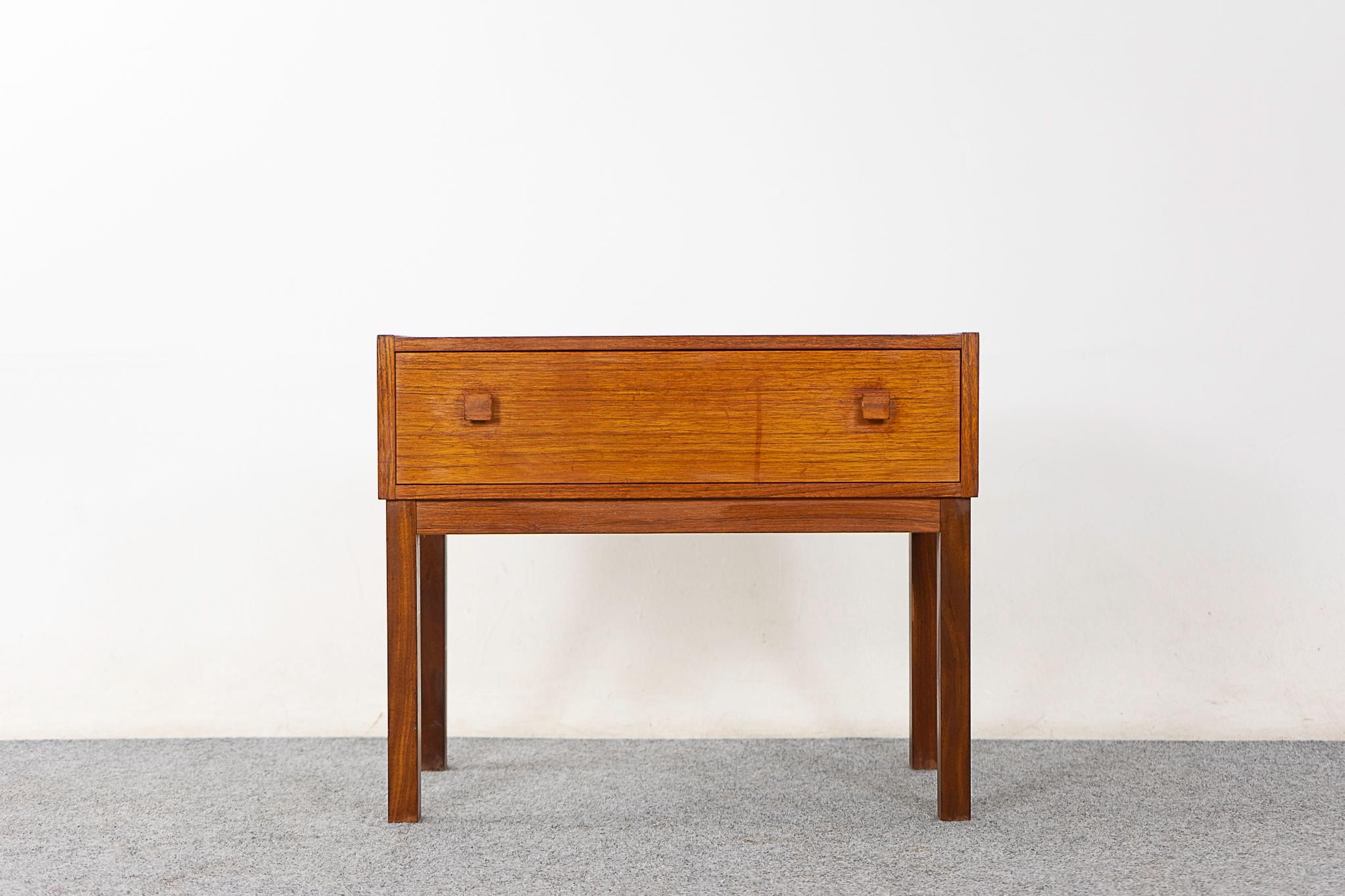 Teak Danish bedside table, circa 1960's. Beautifully veneered case rests on slender legs, handy sleek drawer.