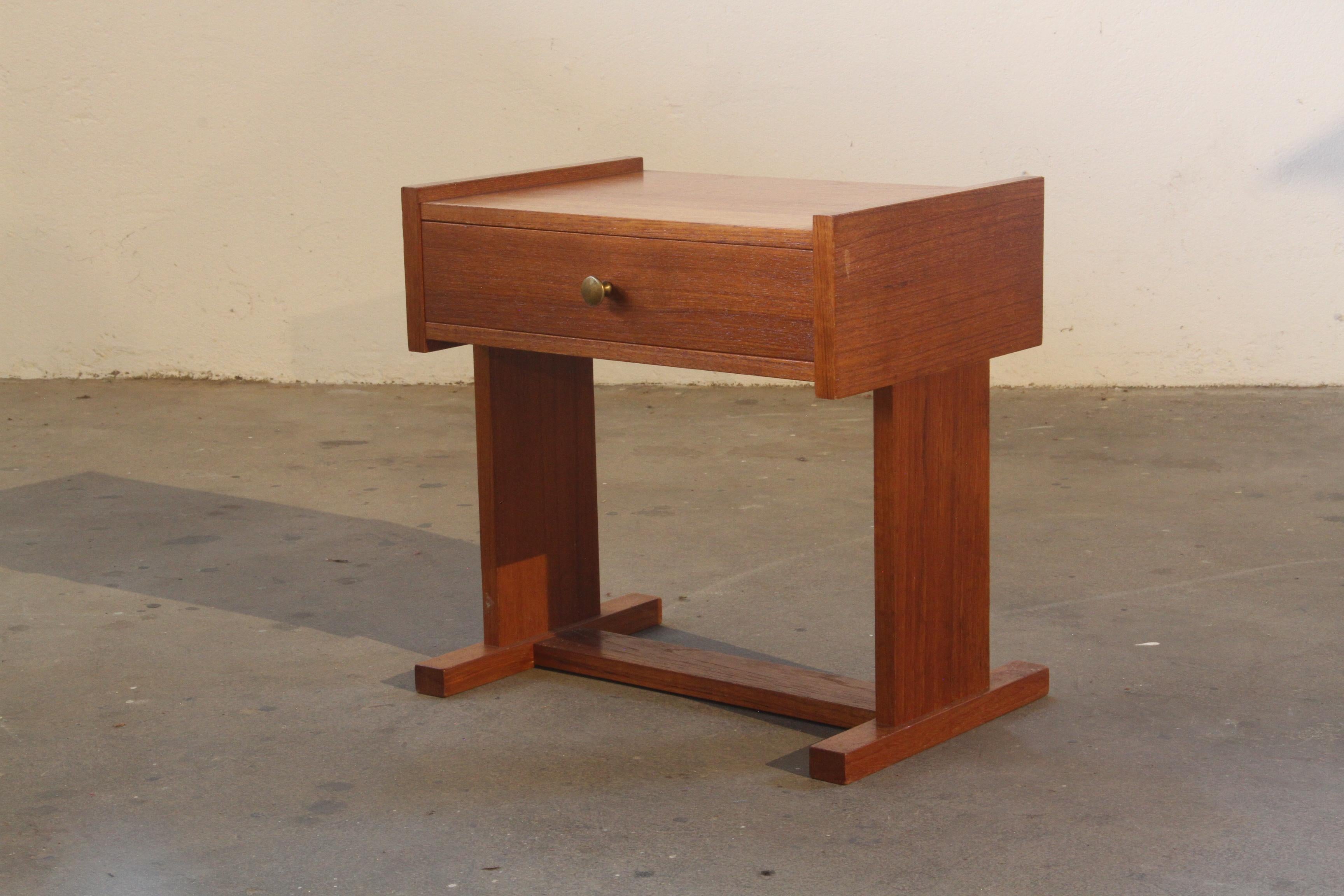 Dieser kleine Nachttisch aus Teakholz hat ein einfaches Design und eine einzige Schublade. Er hat eine gute Größe für ROOMS mit niedrigen Betten oder ebenerdiger Aufstellung. Die Schublade funktioniert gut und bietet praktischen Stauraum für kleine