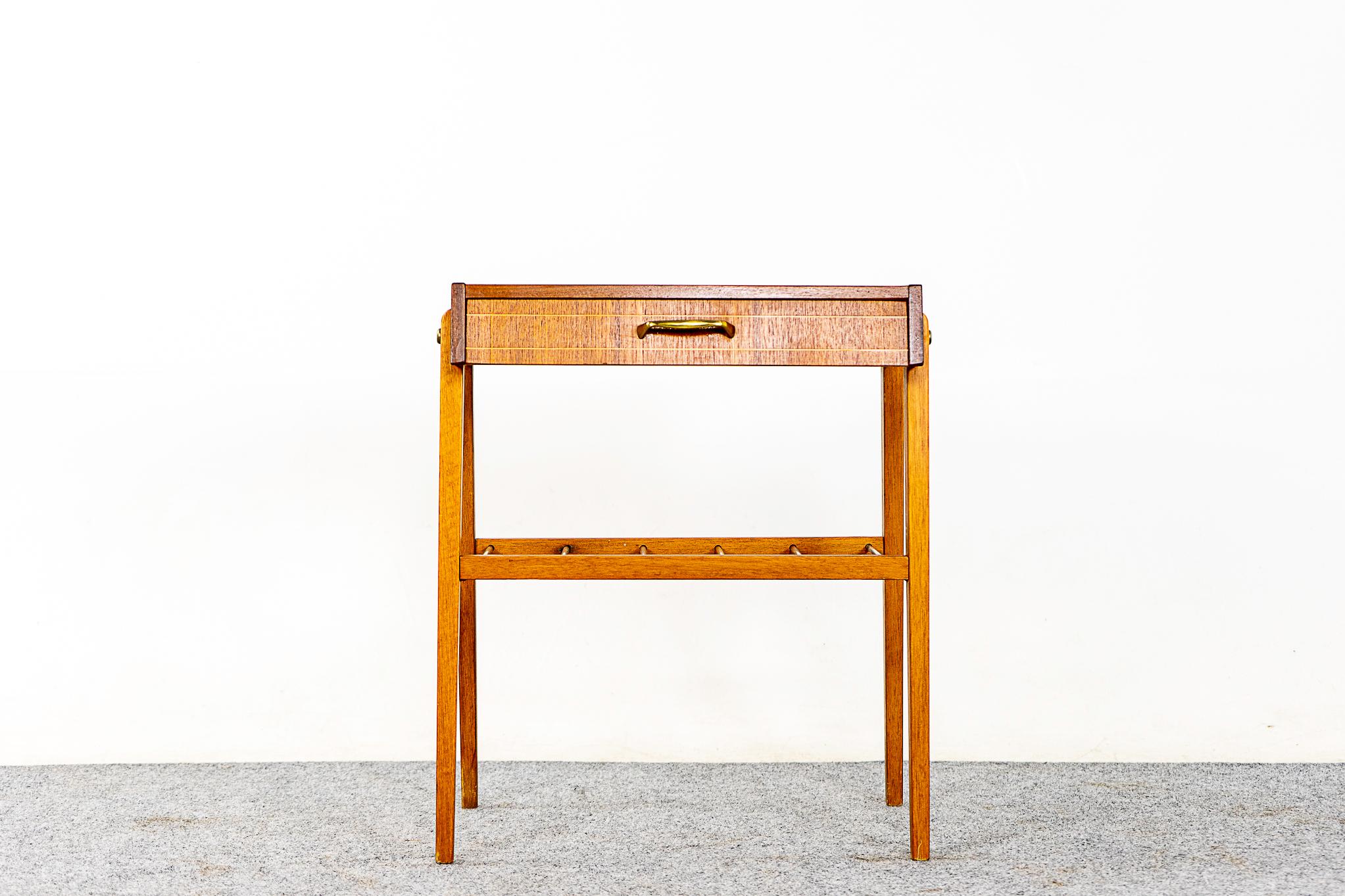 Teak Danish modern bedside table, circa 1960s. Beautifully veneered case rests on slender, tapered legs. Drawer offer storage for small items while metal shelf is perfect for your favorite book.

Unrestored item, good original condition, some marks