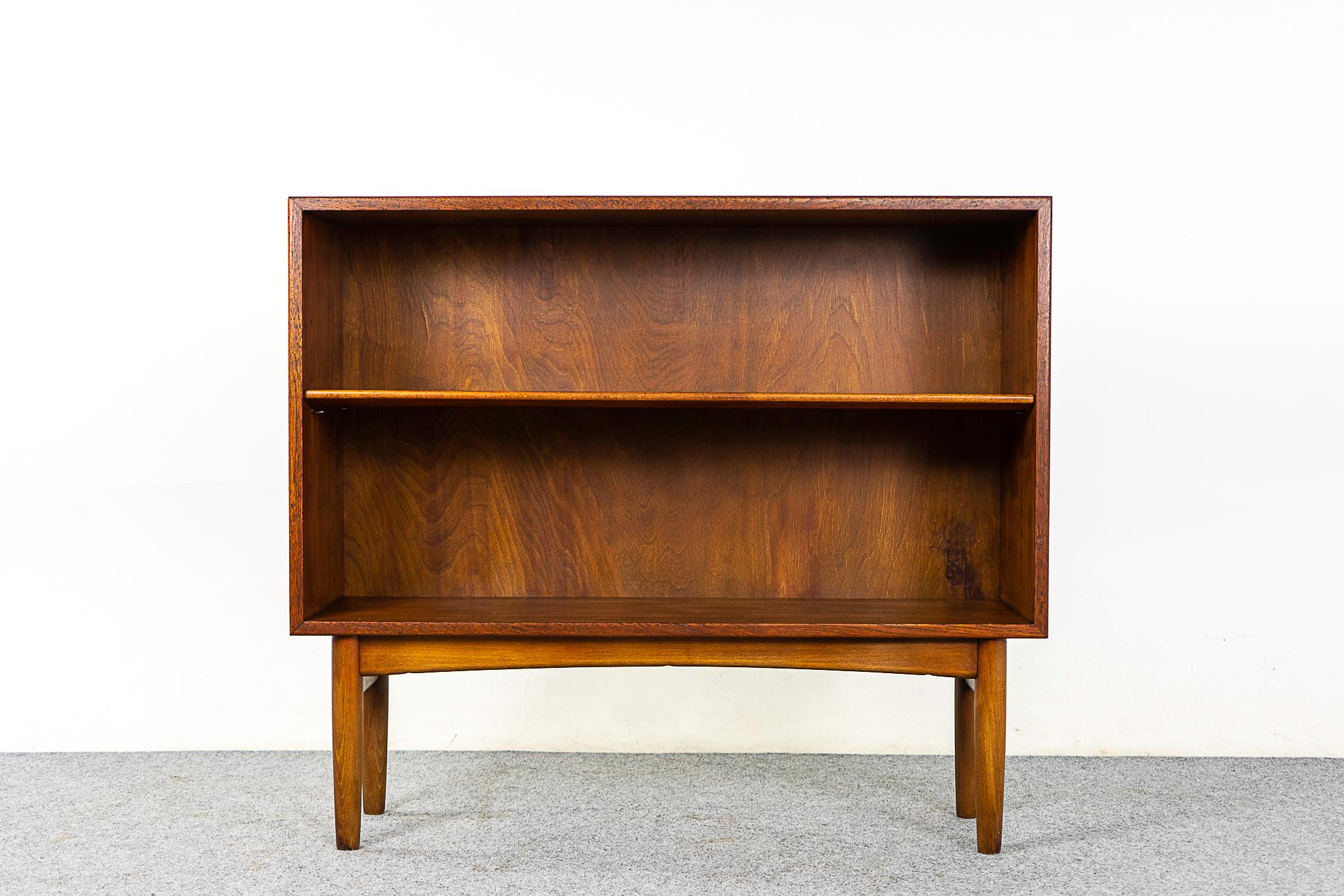Danish Mid Century teak & beech bookcase, circa 1960's. This low profile open bookcase offers removable and adjustable shelving, removable legs and the compact design makes it the perfect condo sized storage solution.

Back panel of bookcase shows