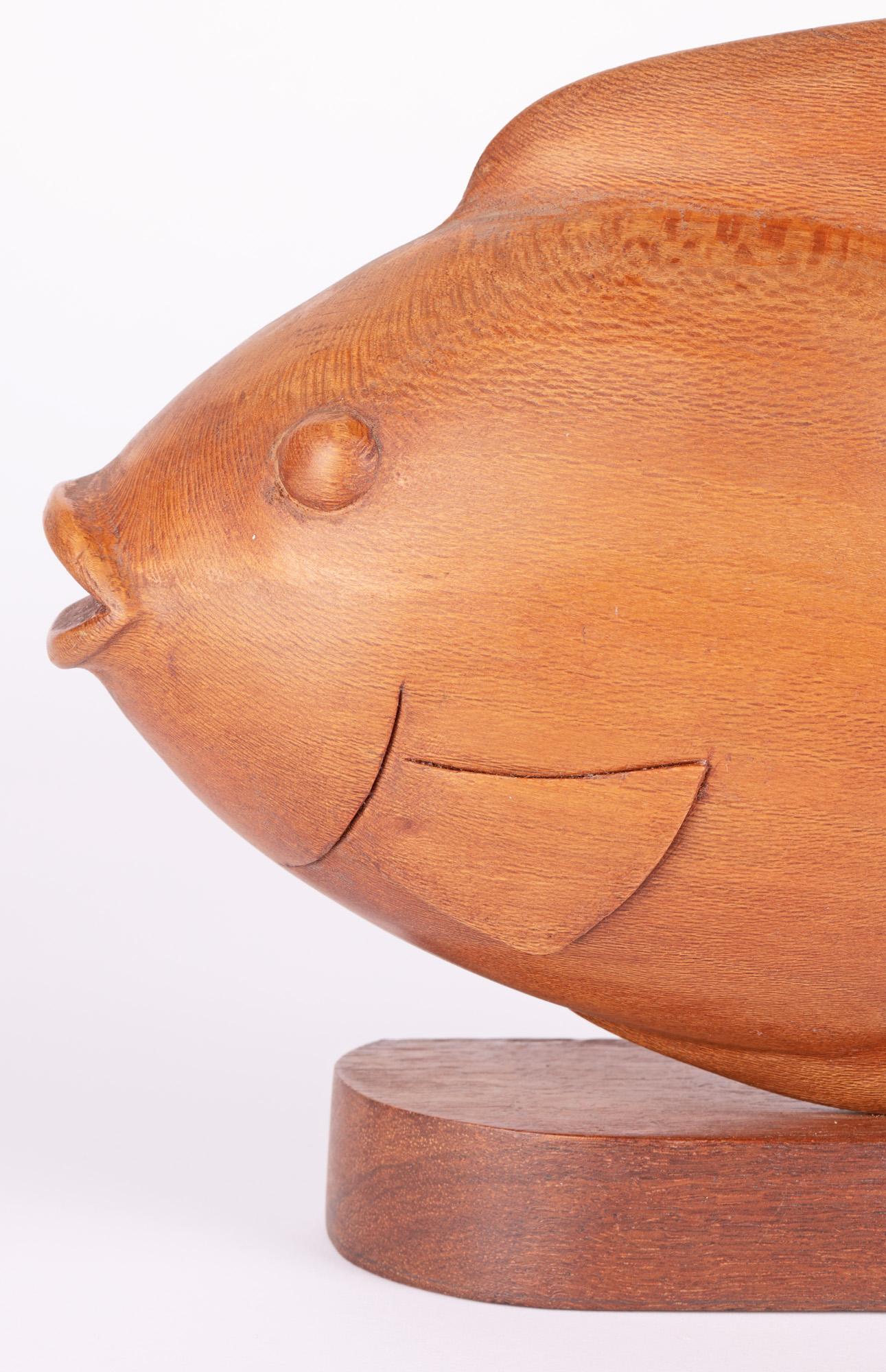 A stylish Danish attributed mid-century carved teak model of a fish mounted on a base,. The fish carved from a single piece of wood and is unusual in that it can be rotated and viewed from two sides. To one side the fish is hand carved with a curved