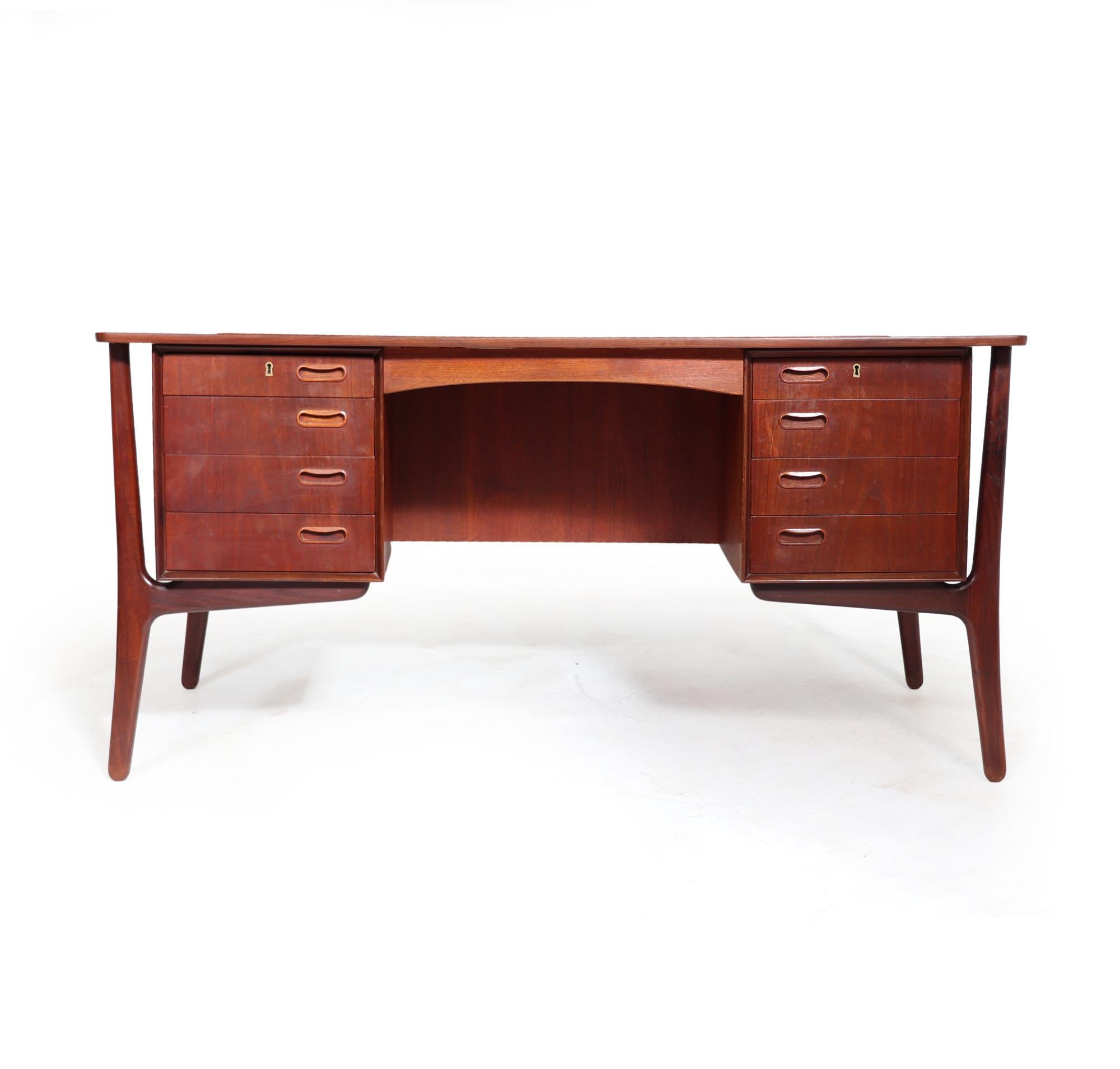 This desk is designed in the 1960s by Svend Age Madsen and manufactured by H.P. Hansen in Denmark. The desk features a curved desktop with beautiful lip detail on the back edge. Sculptural exterior legs support 'floating' banks of drawers with