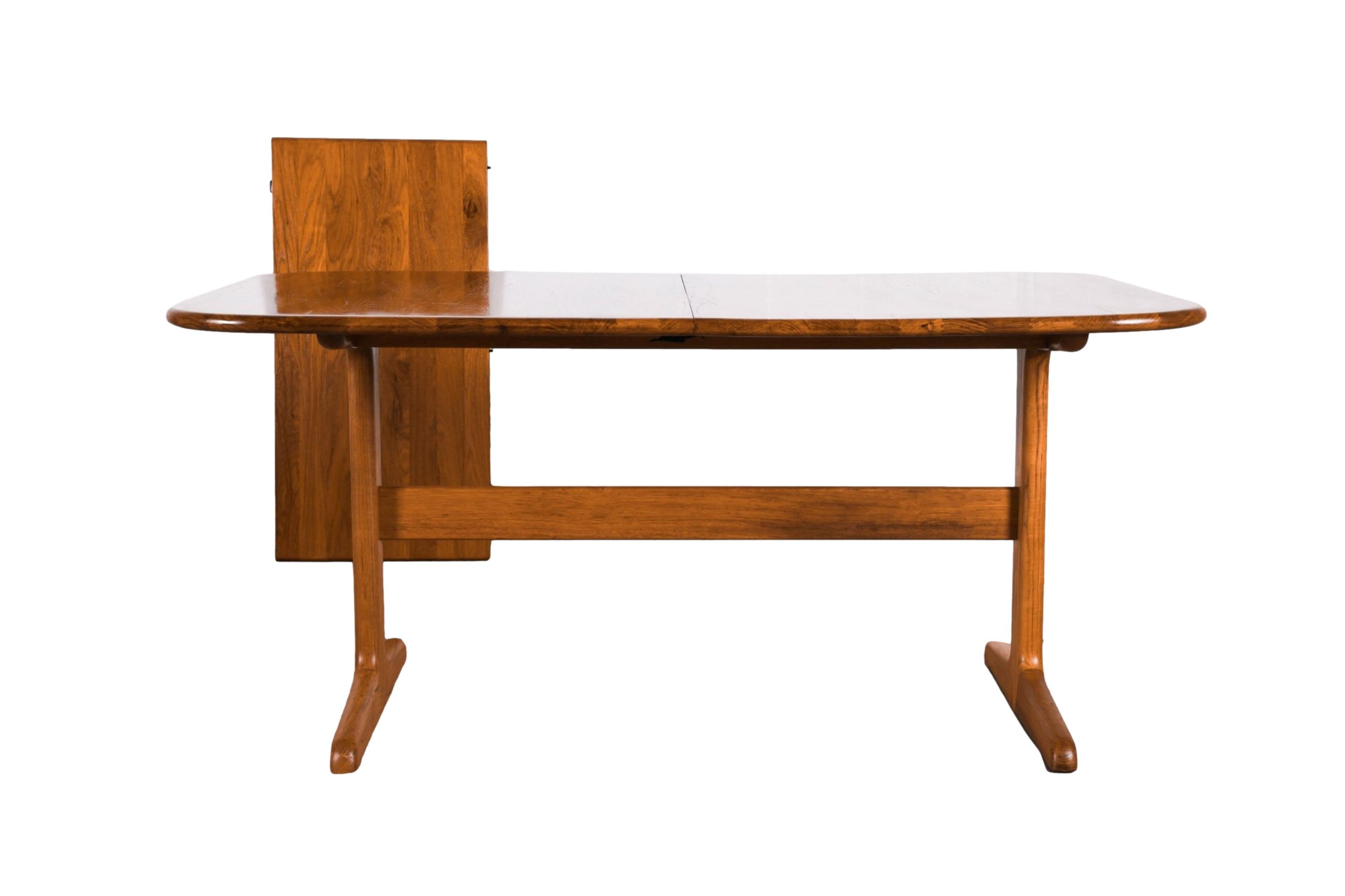 Beautiful Mid-Century Modern expandable dining table, circa 1970’s. Featuring richly grained, gleaming teak and smooth, clean lines characteristic of classic Danish design. This remarkable dining table comes with one extension leaf to accommodate