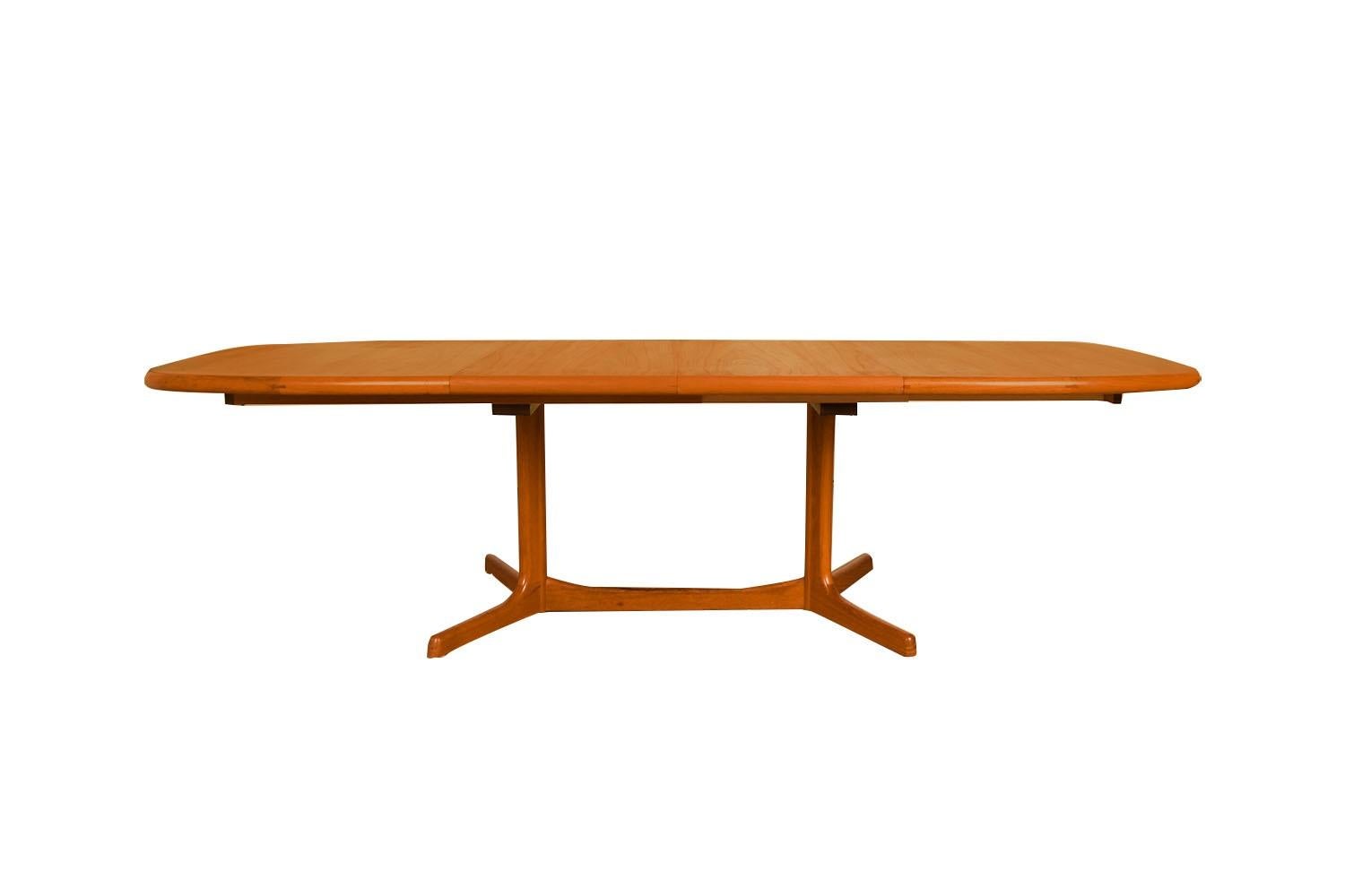 Beautiful Mid-Century Modern expandable dining table, circa 1970’s by Dyrlund. Featuring richly grained, gleaming teak and smooth, clean lines characteristic of classic Danish design. Maker’s label (Dyrlund made in Denmark) present on underside.