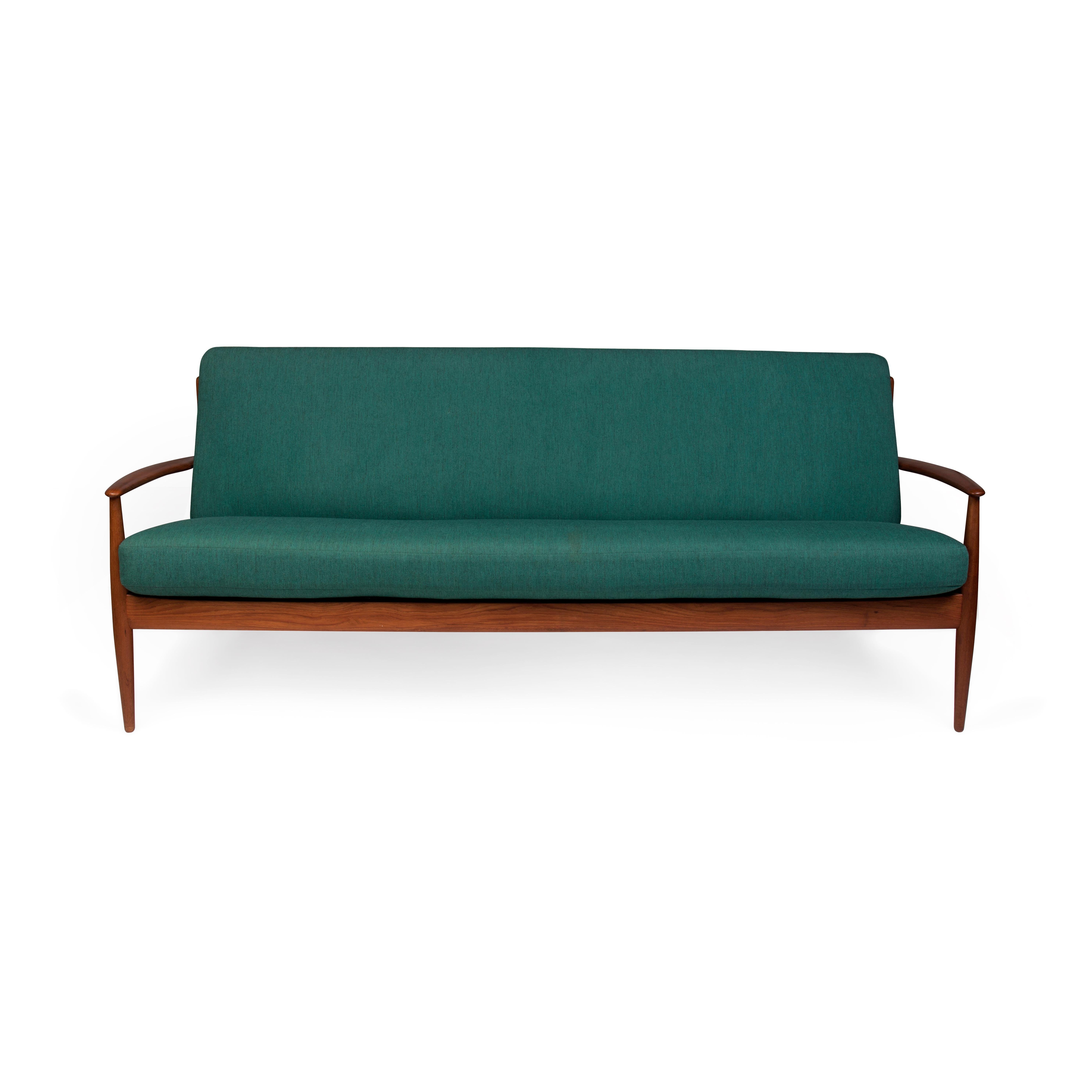 This rare teak sofa designed ca. 1952 by Grete Jalk (1920-2006) has its original seat and back cushions with spring coils. The cushions are upholstered with the original green fabric designed by Grete Jalk (verified by Grete Jalk