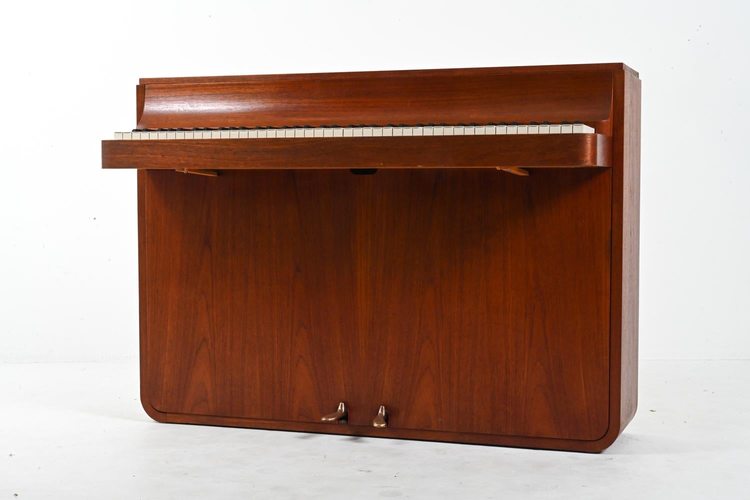 Versetzen Sie sich mit diesem meisterhaft gefertigten dänischen Teakholz-Klavier aus der Mitte des Jahrhunderts des renommierten Louis Zwicki in die Vergangenheit. Aus dem Herzen der 1960er Jahre, einer Zeit, in der Design und Handwerkskunst in